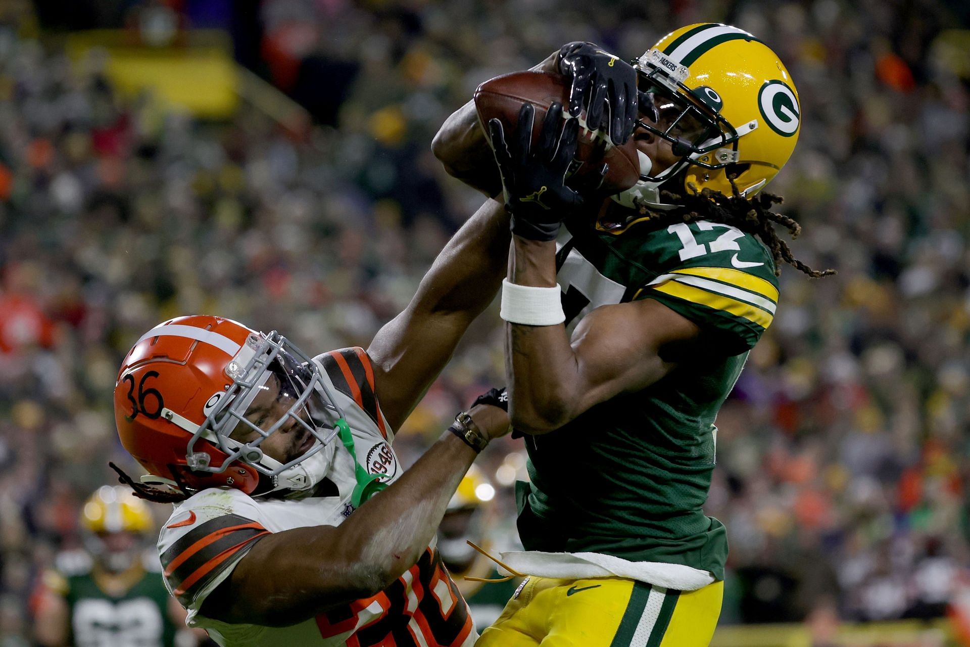 Former Green Bay Packers wide receiver Davante Adams wrestles a pass from a defender.