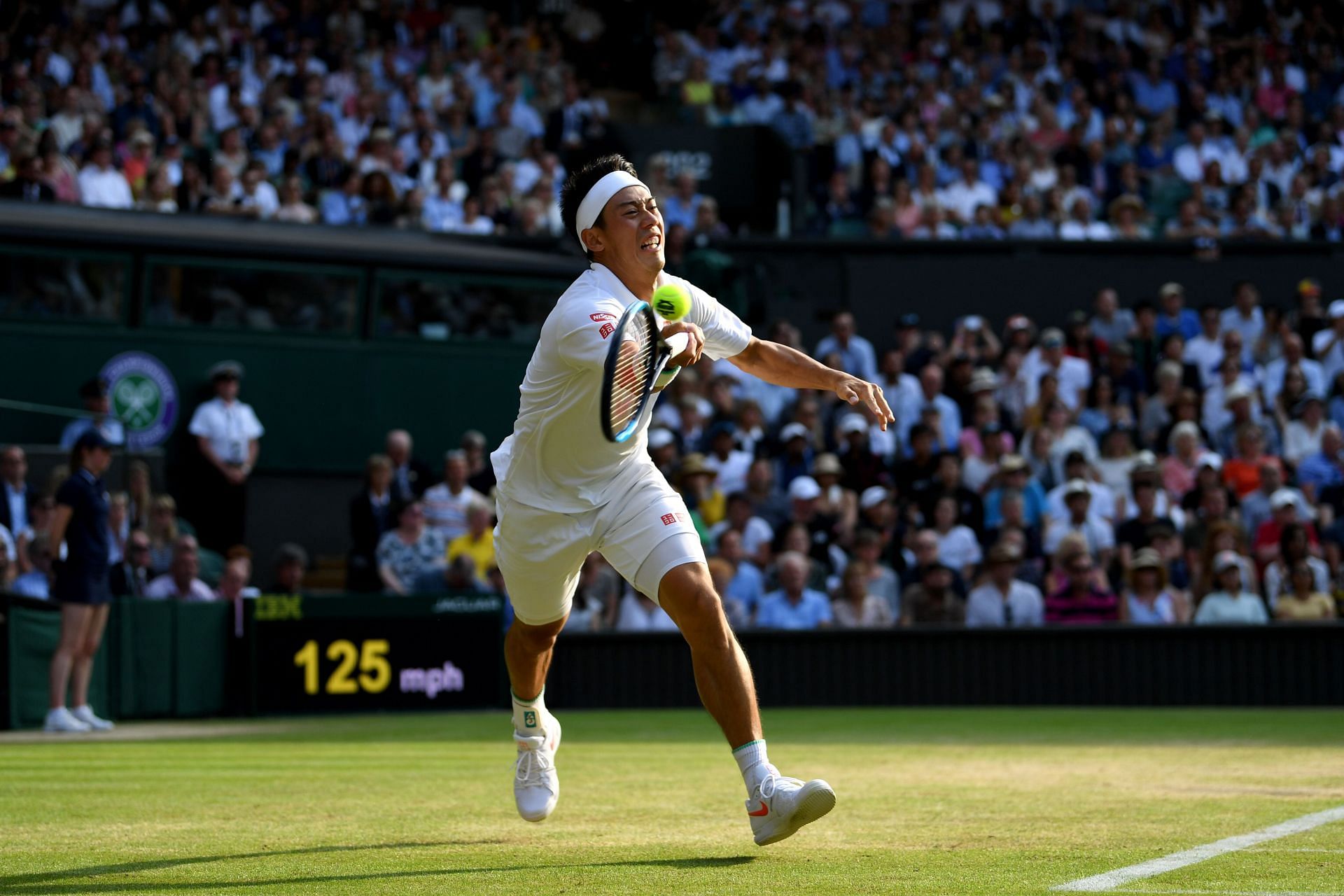 Kei Nishikori stretches to reach a ball at Wimbledon