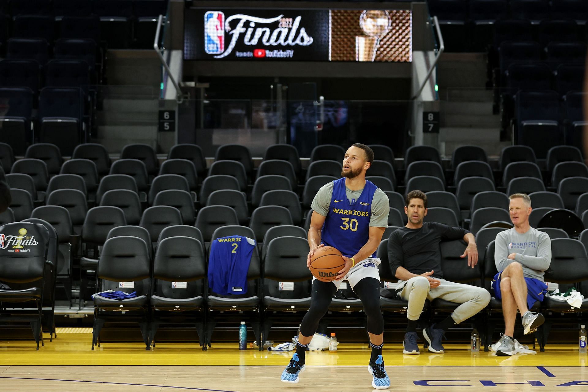 Warriors coach Steve Kerr looks on as Steph Curry goes through his routine during 2022 NBA Finals - Media Day