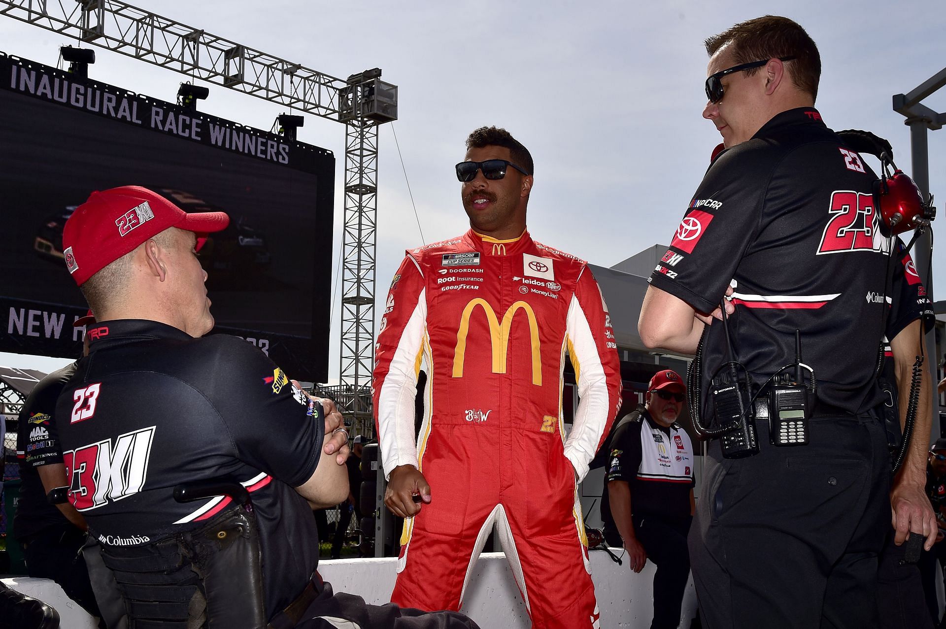 Bubba Wallace Jr. and crew talk on the grid during qualifying for the NASCAR Cup Series Enjoy Illinois 300 at WWT Raceway