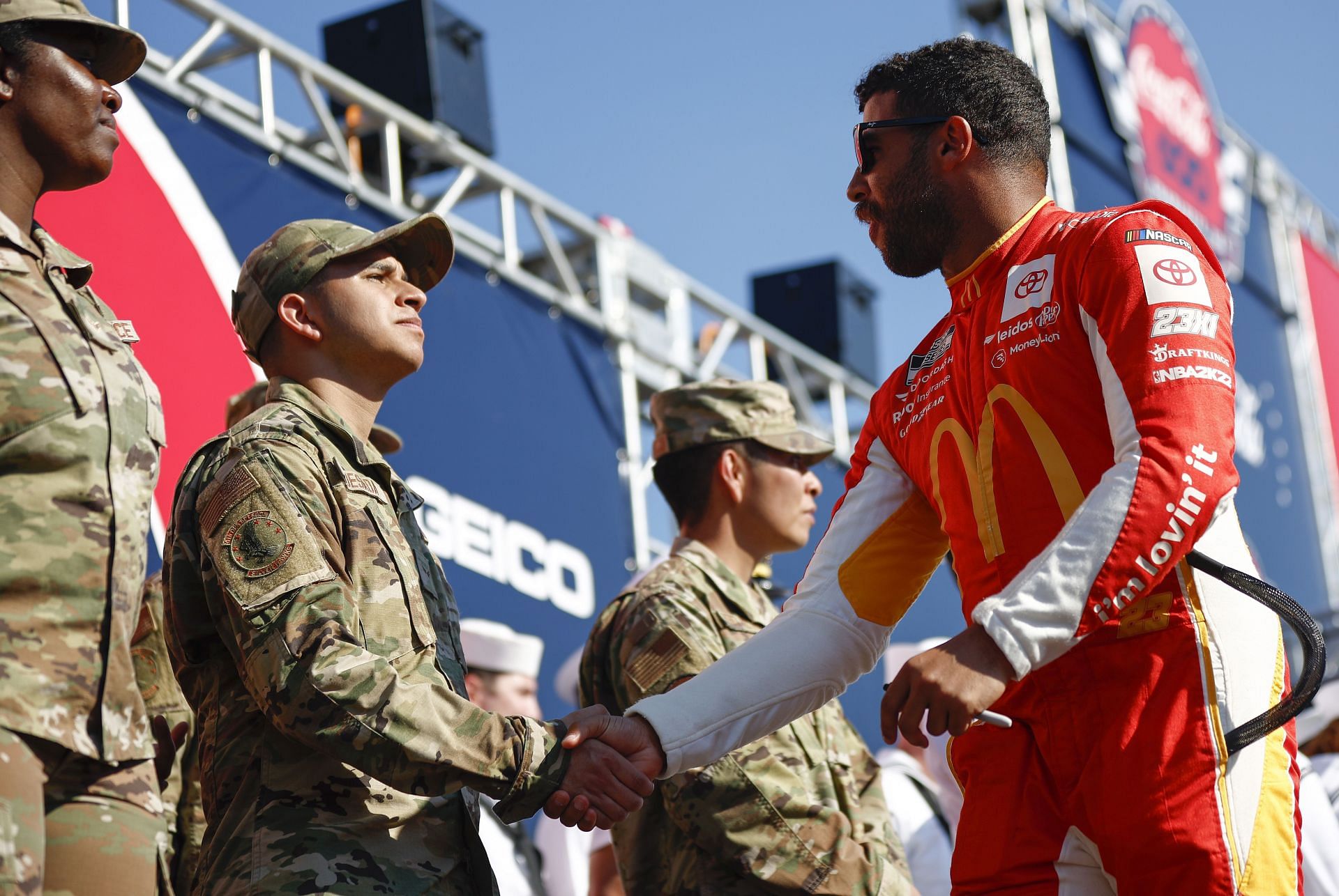 Bubba Wallace Jr., shakes hands with a service member during driver intros before the 2022 NASCAR Cup Series Coca-Cola 600 at Charlotte Motor Speedway in Concord, North Carolina. (Photo by Jared C. Tilton/Getty Images)