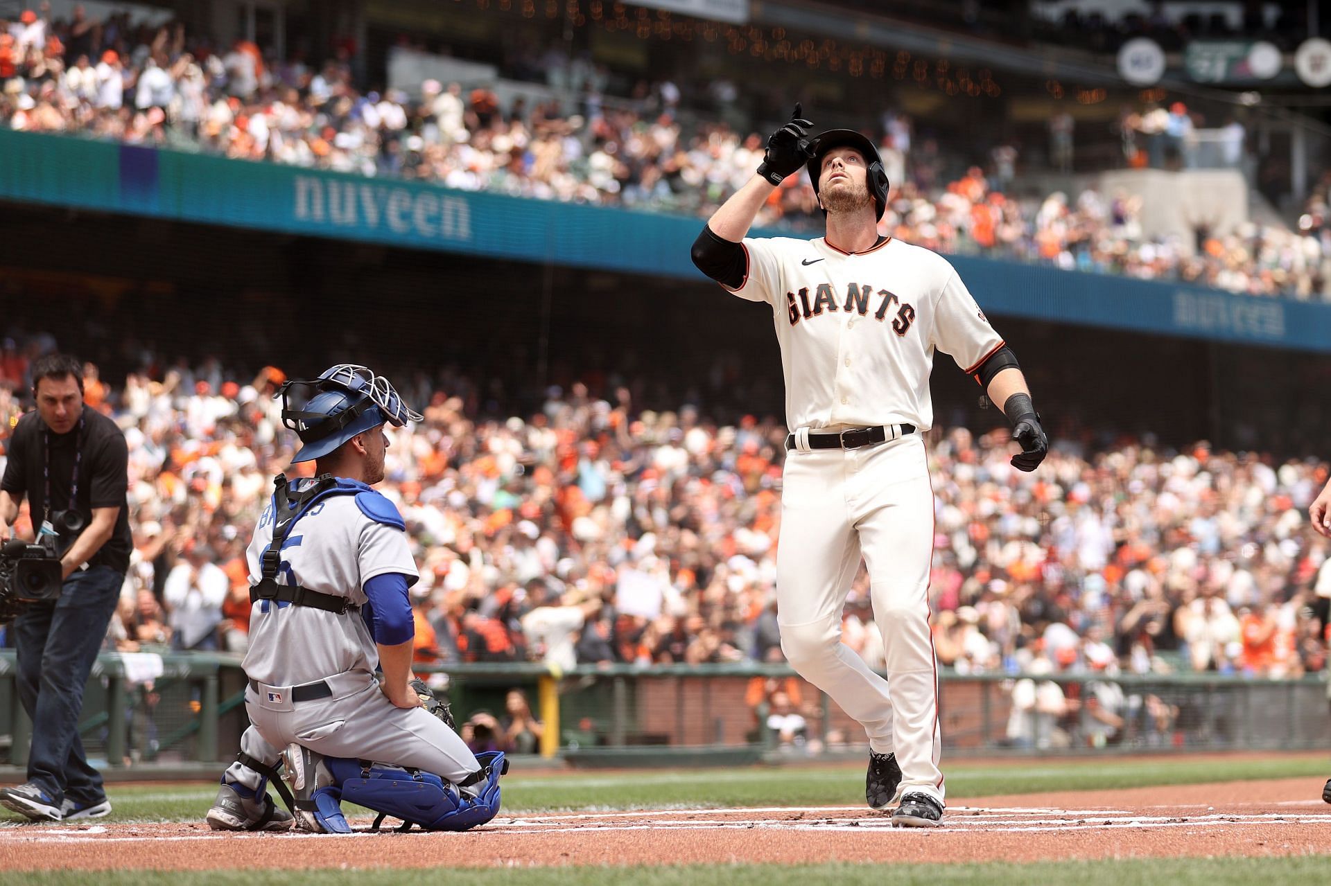 Austin Slater of the San Francisco Giants points to the sky as he crosses home plate after a leadoff home run against the Los Angeles Dodgers.