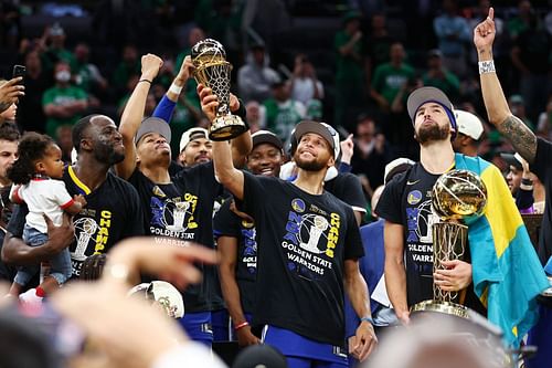 Steph Curry of the Golden State Warriors raises the Bill Russell NBA Finals Most Valuable Player award.