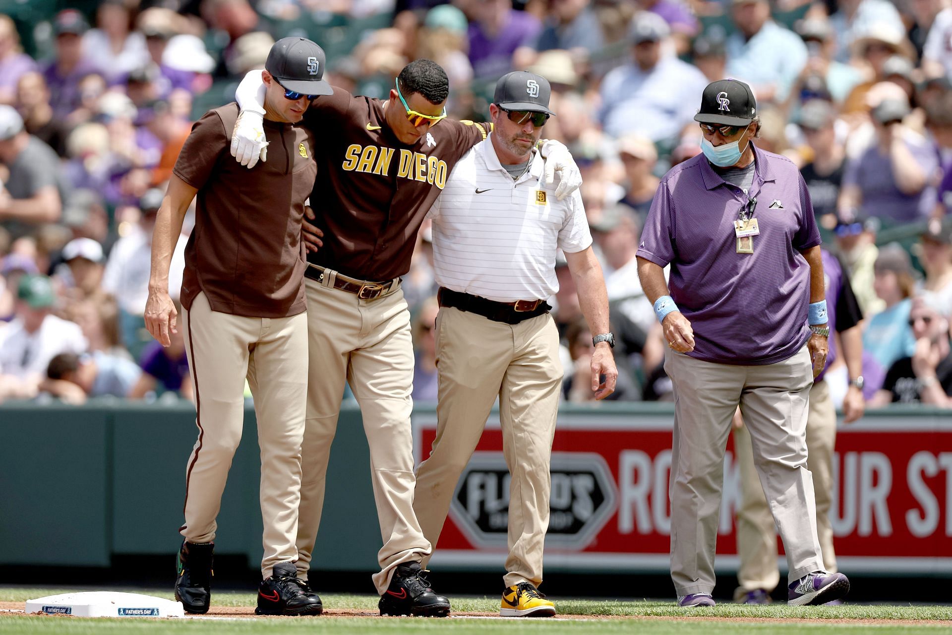 San Diego Padre Manny Machado is helped off the field after suffering an injury during today&#039;s game against the Colorado Rockies.