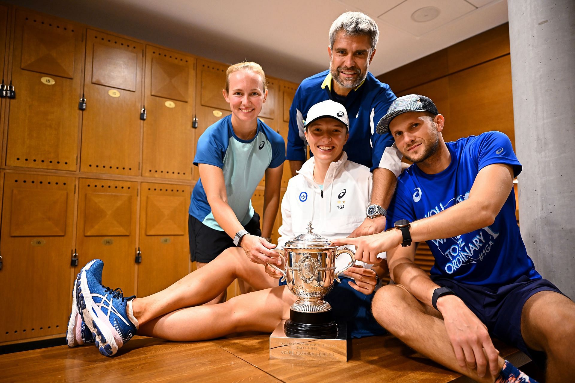 Iga Swiatek and her team pose with the 2022 French Open title.