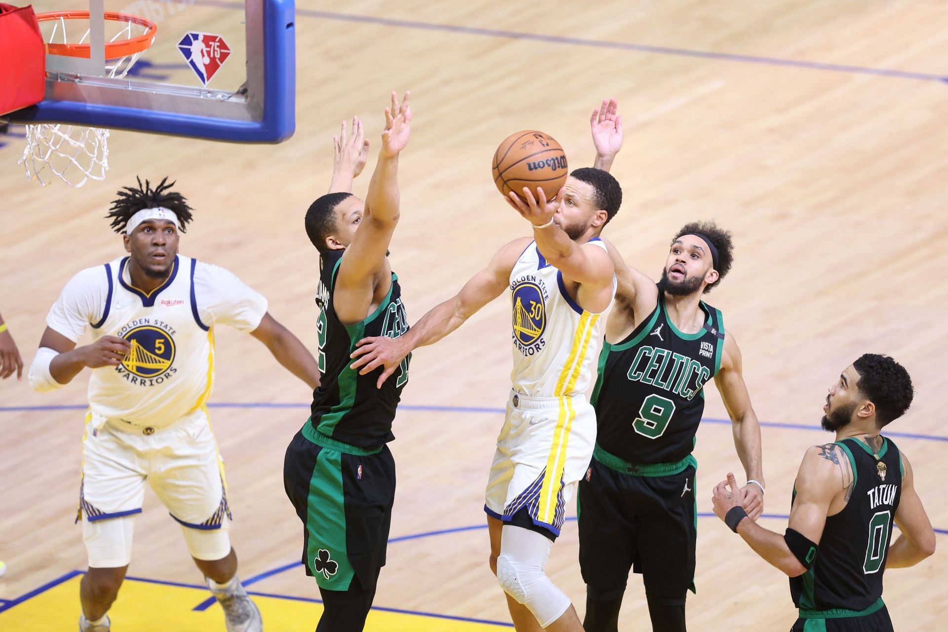 Steph Curry #30 of the Golden State Warriors drives to the basket against Grant Williams #12, Derrick White #9 and Jayson Tatum #0 of the Boston Celtics