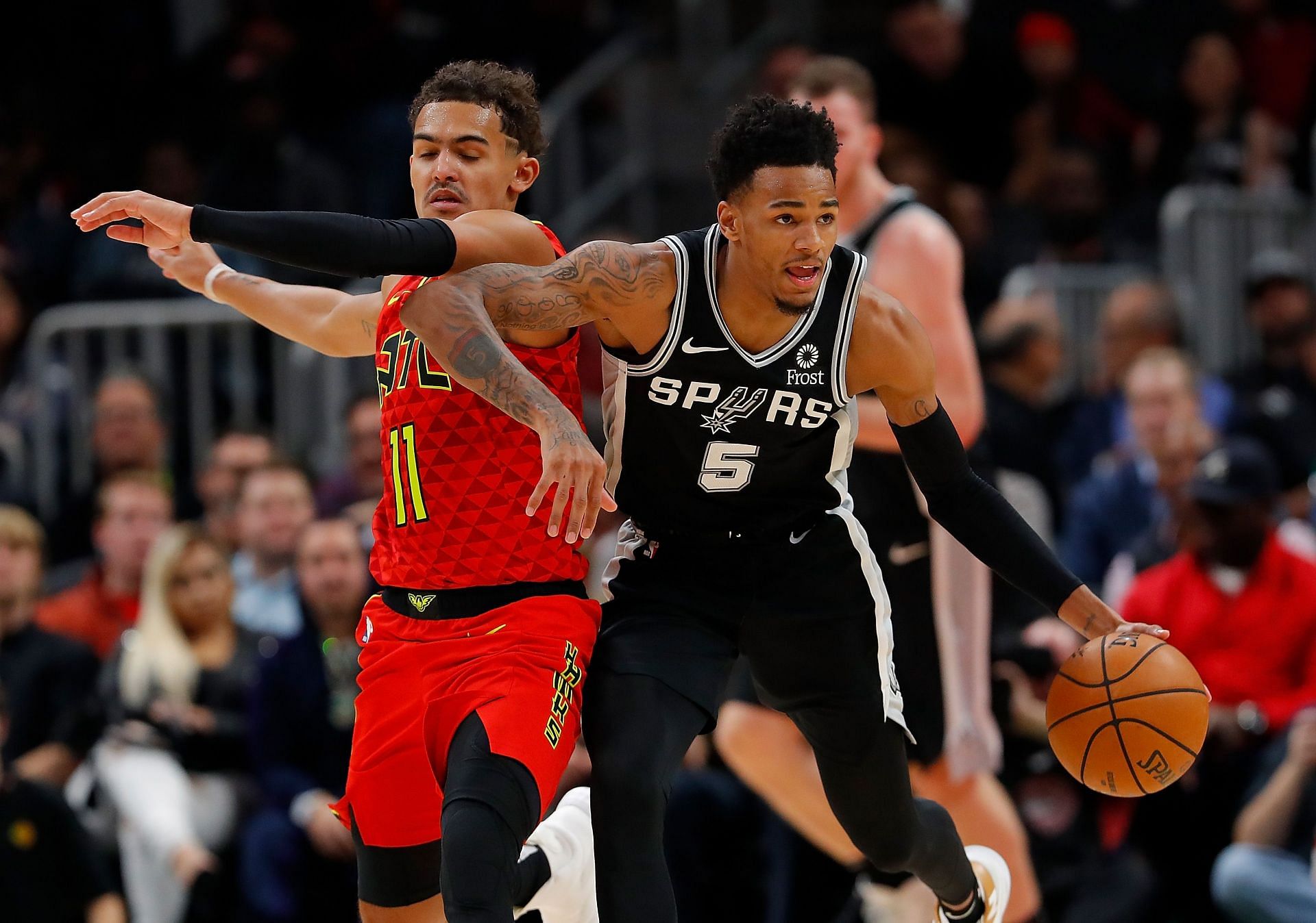 Dejounte Murray of the San Antonio Spurs grabs a loose ball against Trae Young of the Atlanta Hawks at State Farm Arena on Nov. 5, 2019, in Atlanta, Georgia.