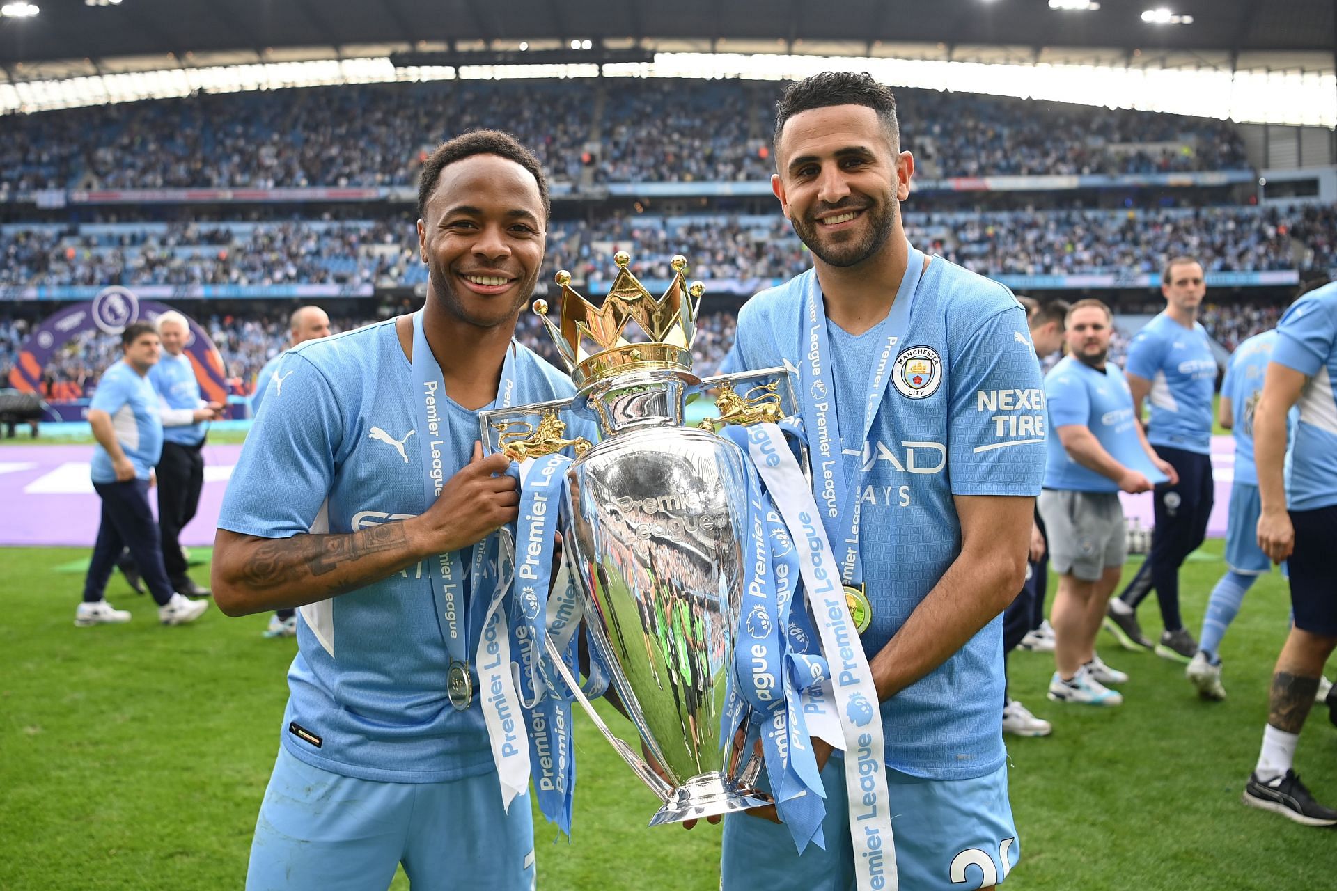 Raheem Sterling poses alongside Riyad Mahrez with the Premier League trophy