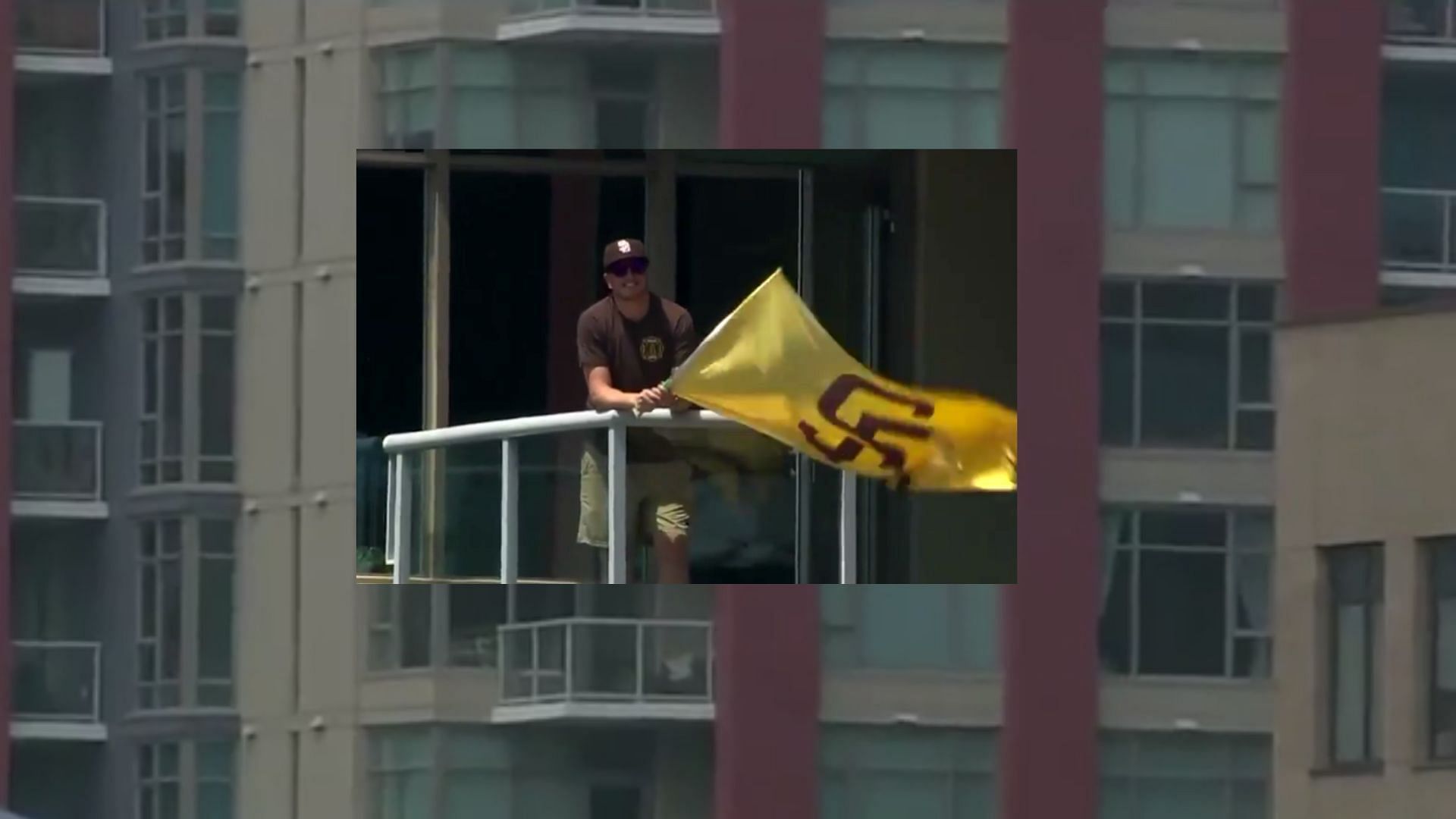 San Diego Padres fan waves a flag from his apartment adjacent to the stadium.