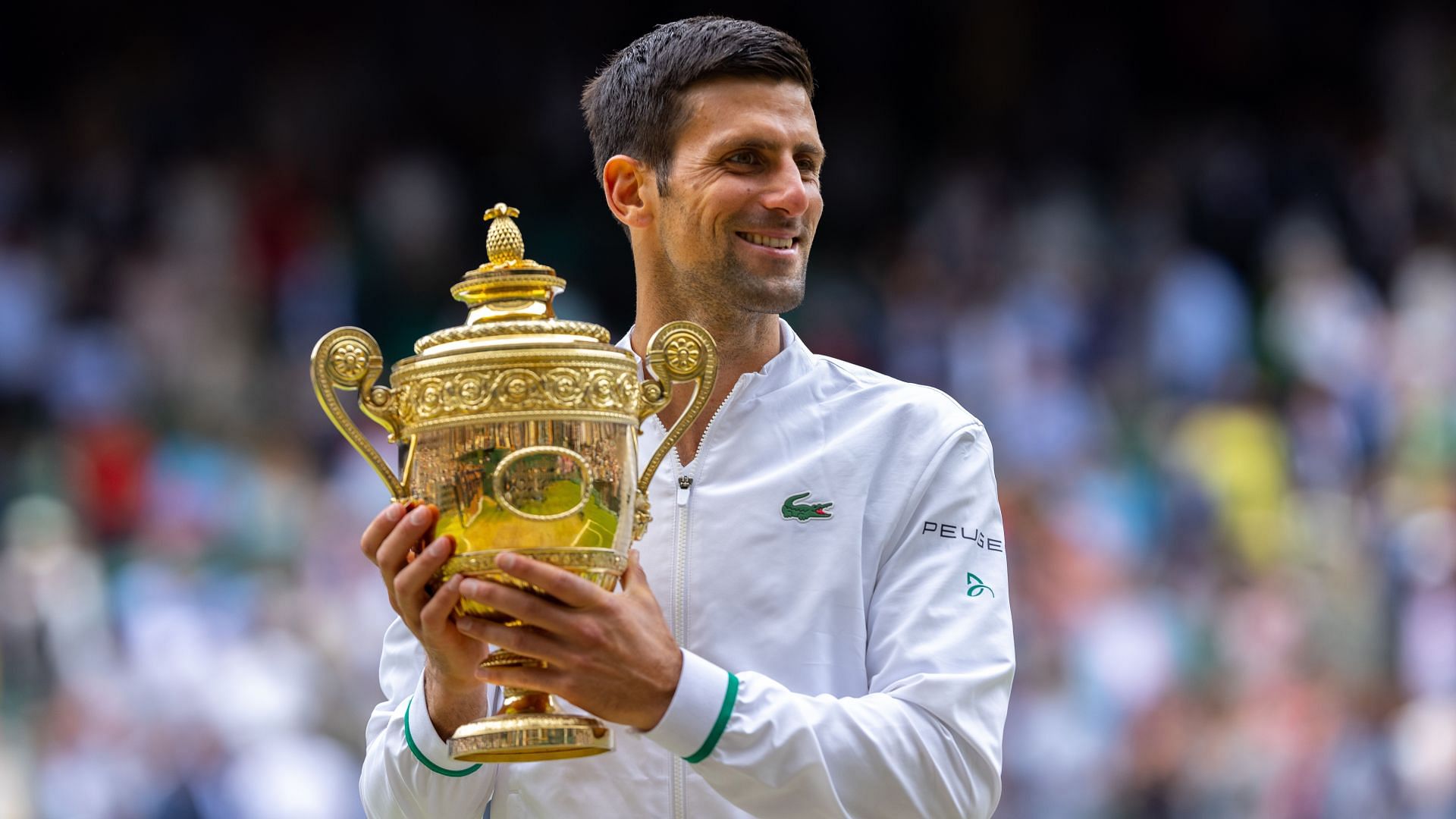 Novak Djokovic poses with the 2021 Wimbledon trophy.