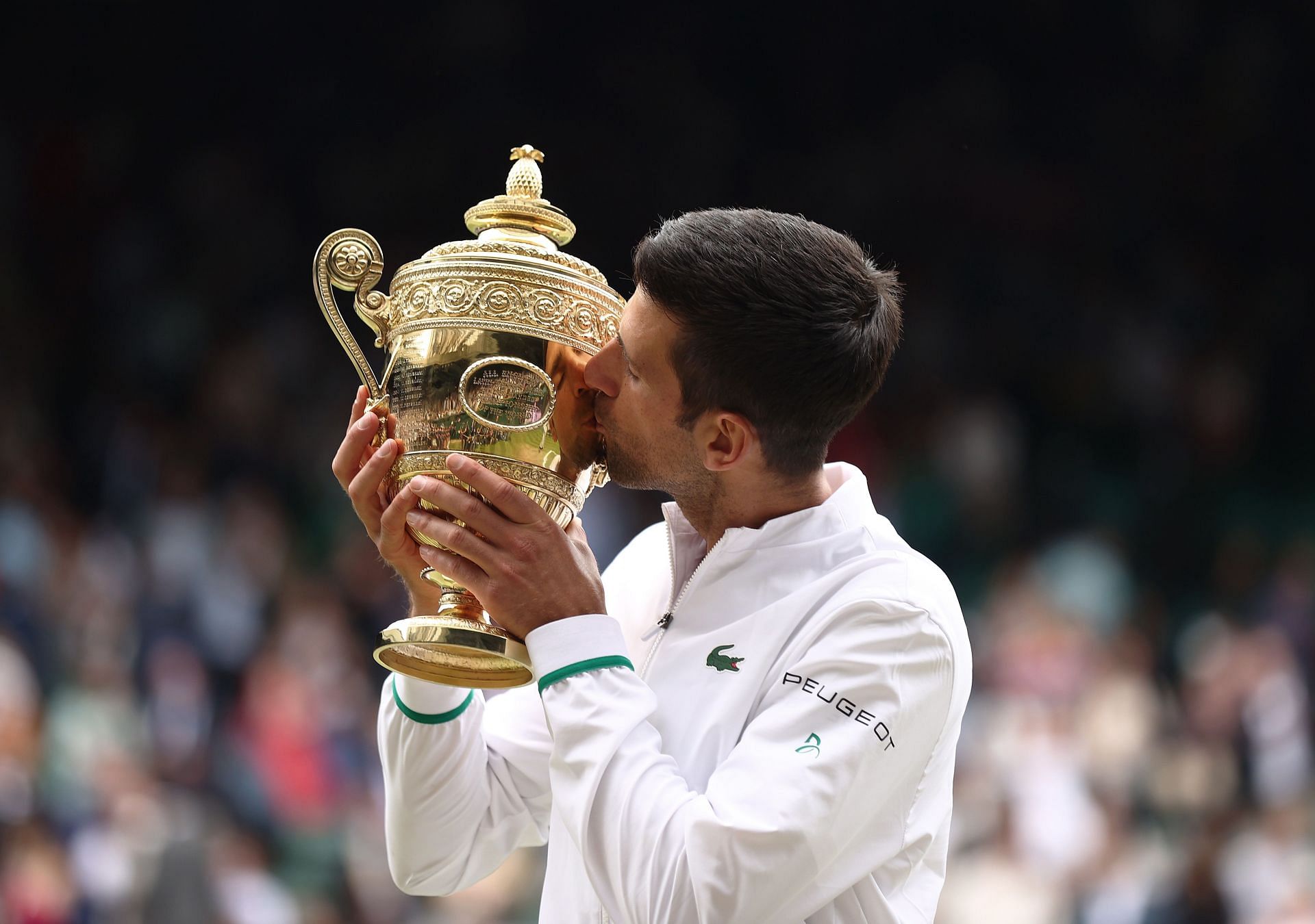 Novak Djokovic kisses the coveted Wimbledon trophy 2021. Photo by Julian Finney/Getty Images