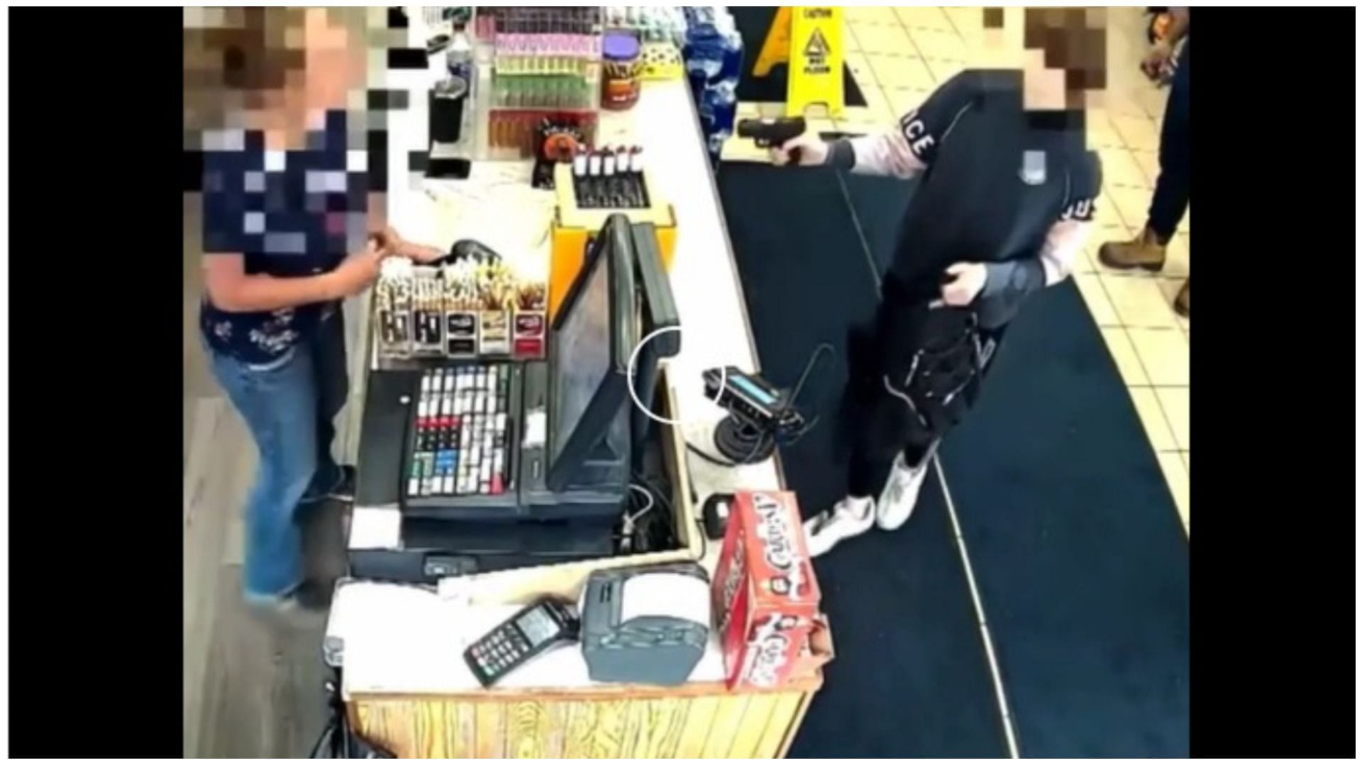 A viral video screengrab shows a boy pointing a gun at a store&#039;s cashier (Image via Reddit)