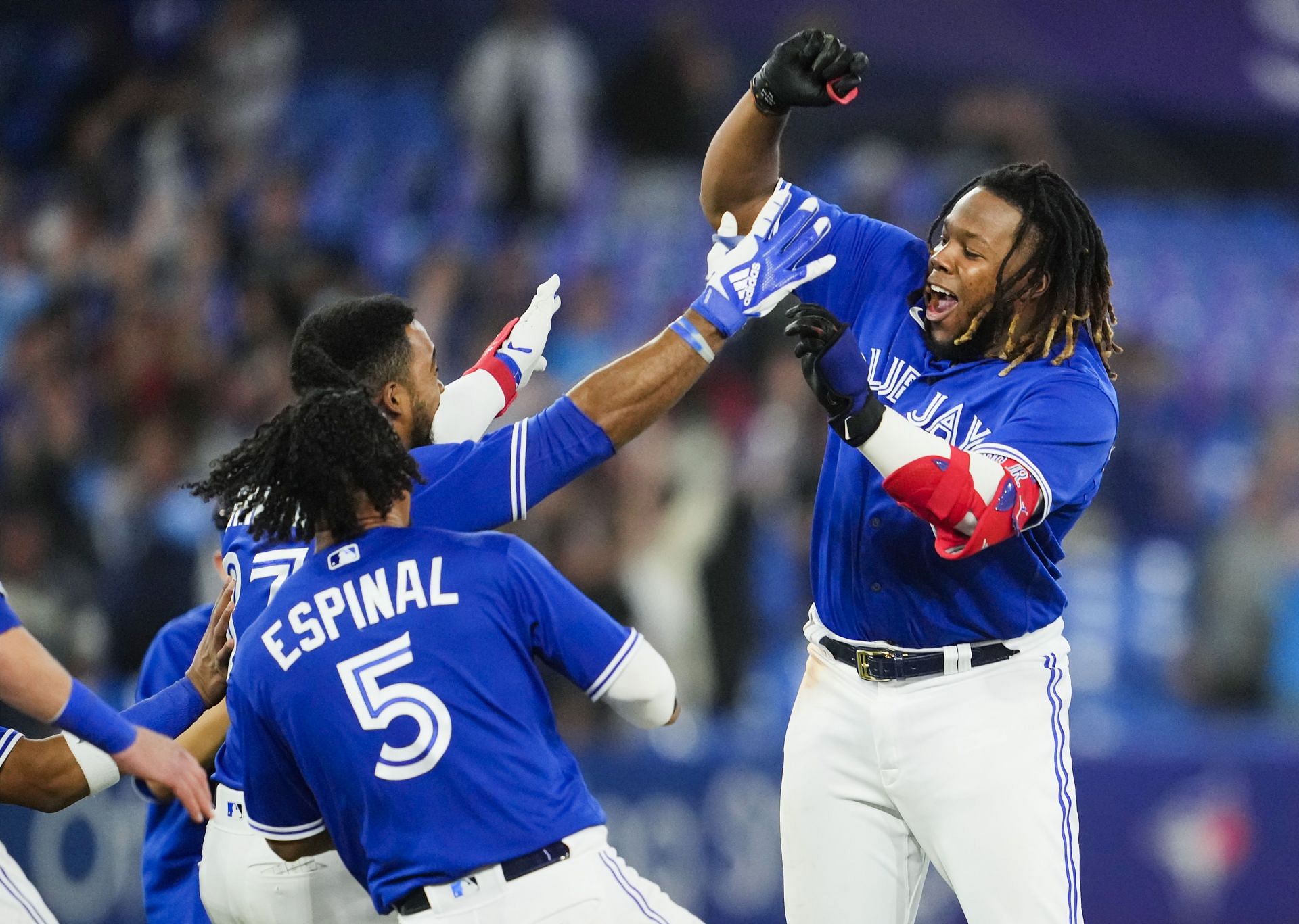 Vladimir Guerrero Jr. celebrates with teammates after a walk-off victory against the Boston Red Sox.