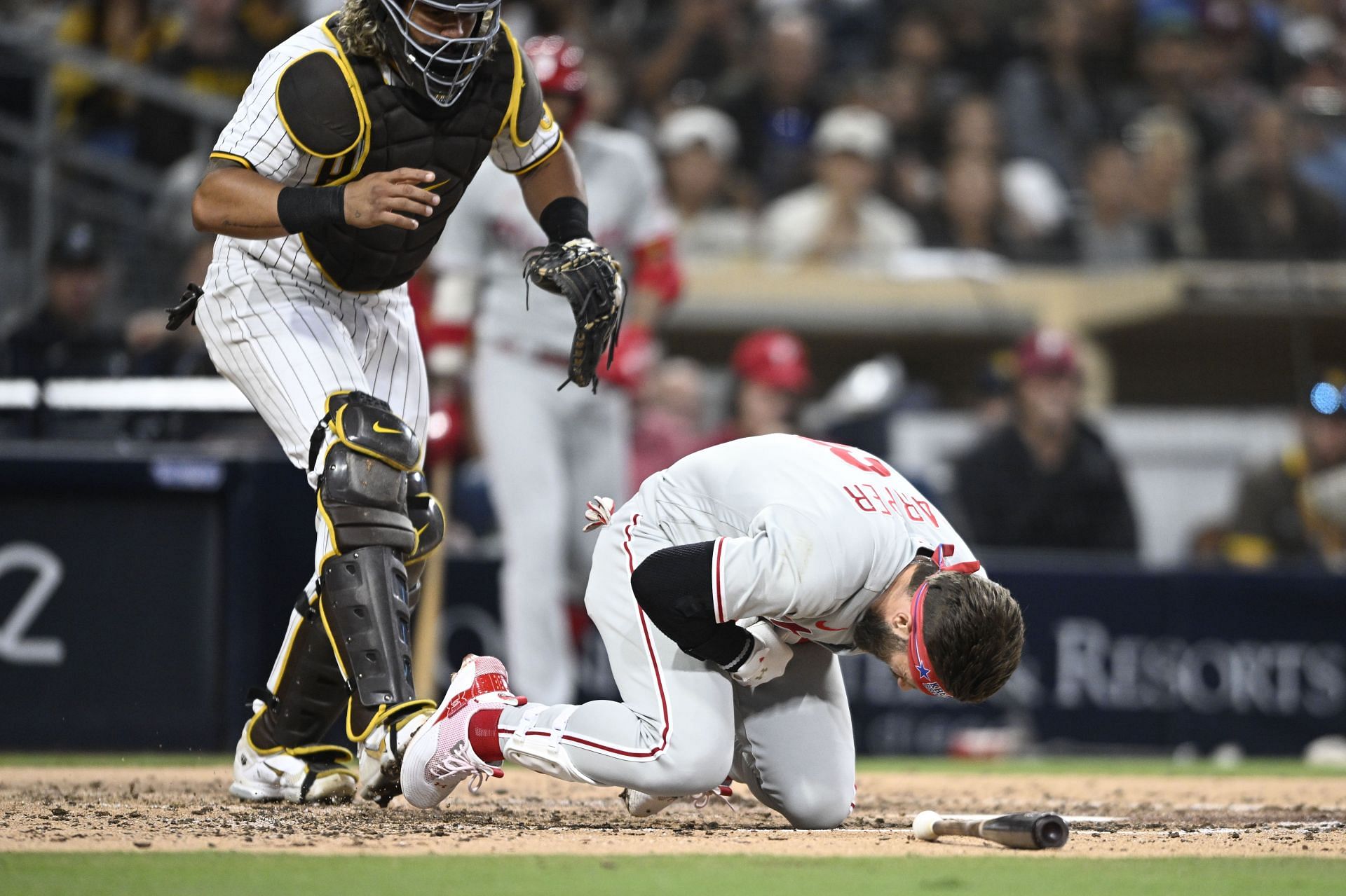 Bryce Harper falls after being hit with a pitch as Jorge Alfaro of the San Diego Padres looks on.