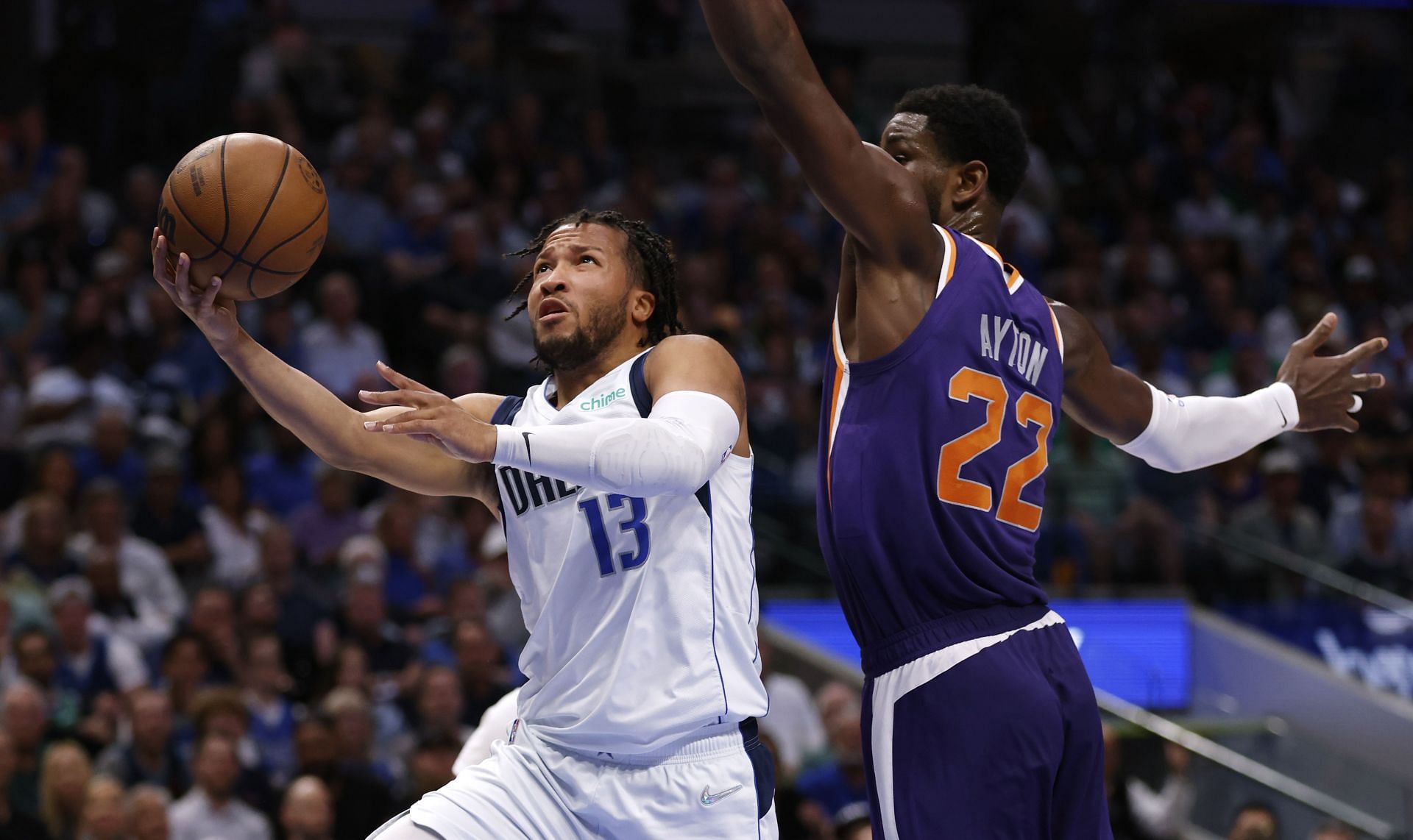 Jalen Brunson of the Dallas Mavericks drives against Deandre Ayton of the Phoenix Suns