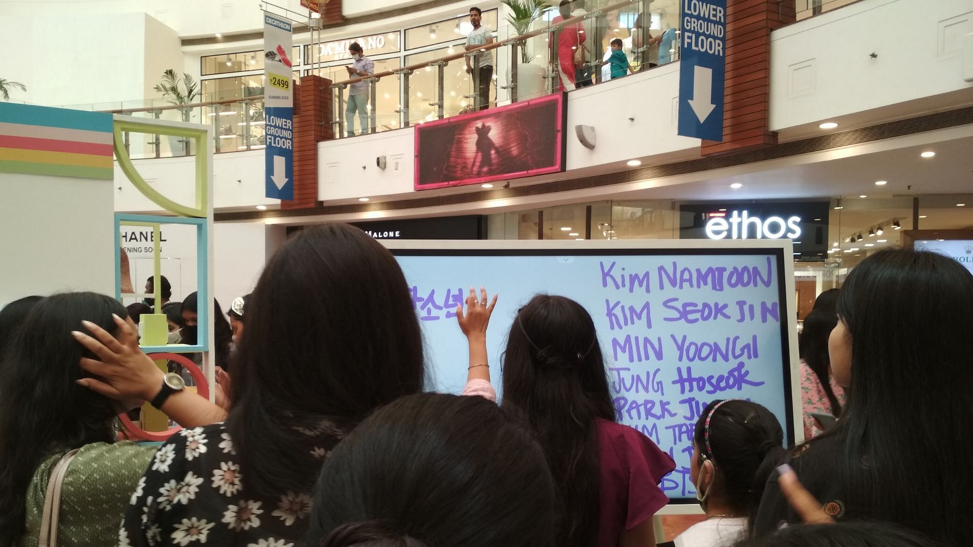 Fans participating in an art event by writing their bias name at Korea Fair in India (Image via Sportskeeda)