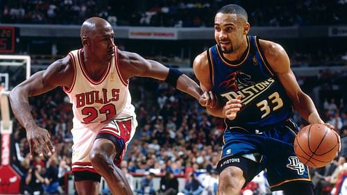 Grant Hill driving the ball against Michael Jordan