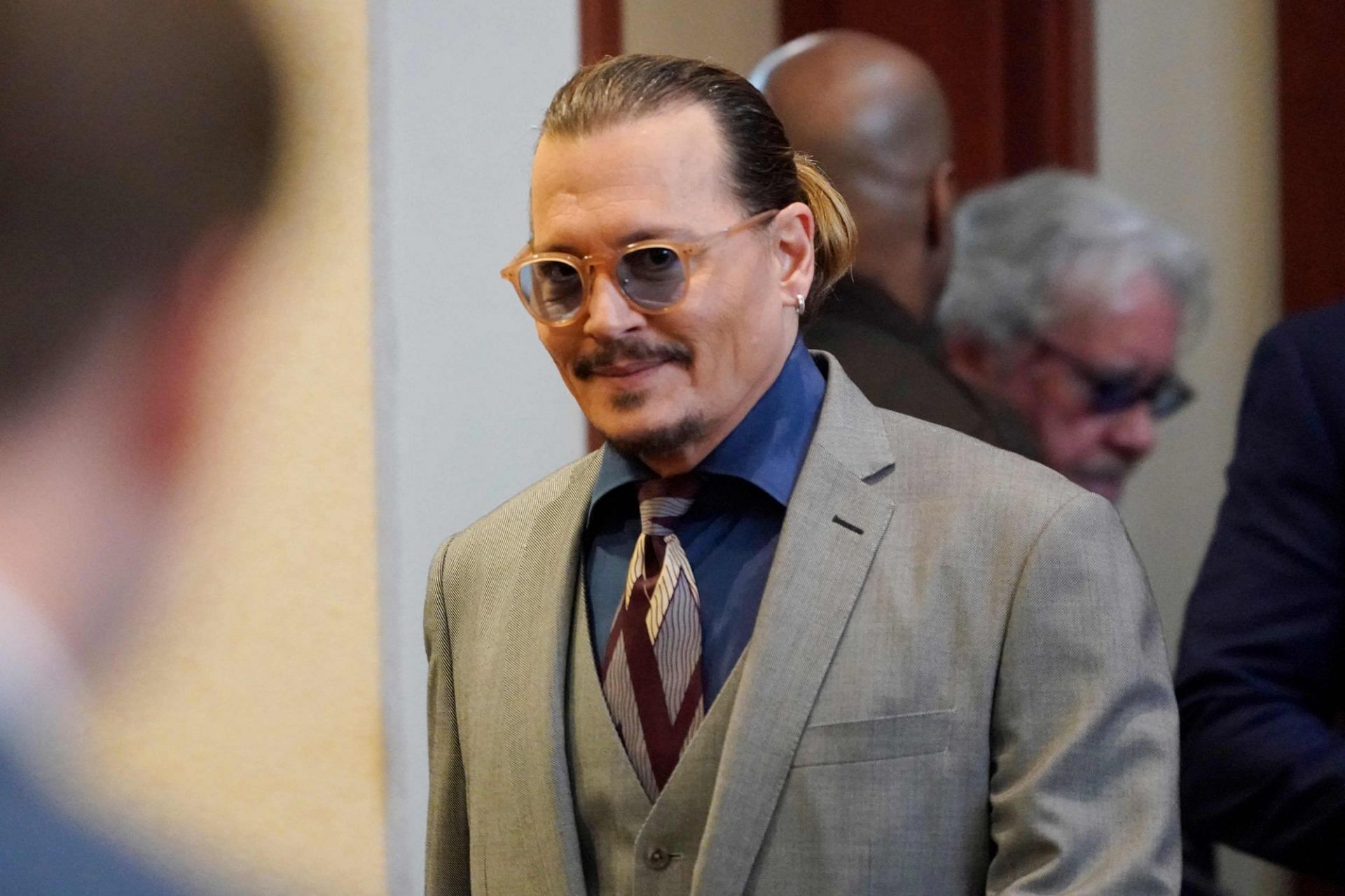 Security helps Johnny Depp outside hotel (Image via GC Images)
