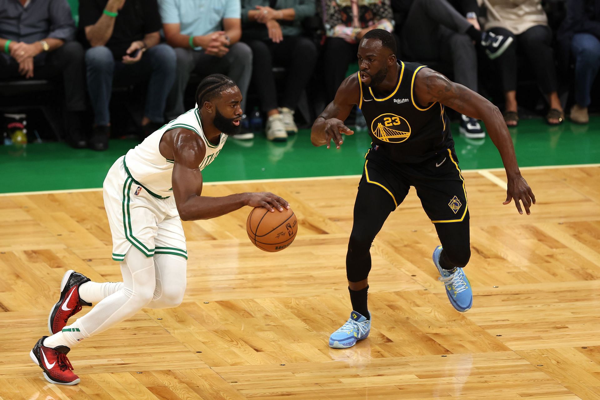 Jaylen Brown of the Boston Celtics drives to the basket defended by Draymond Green of the Golden State Warriors.