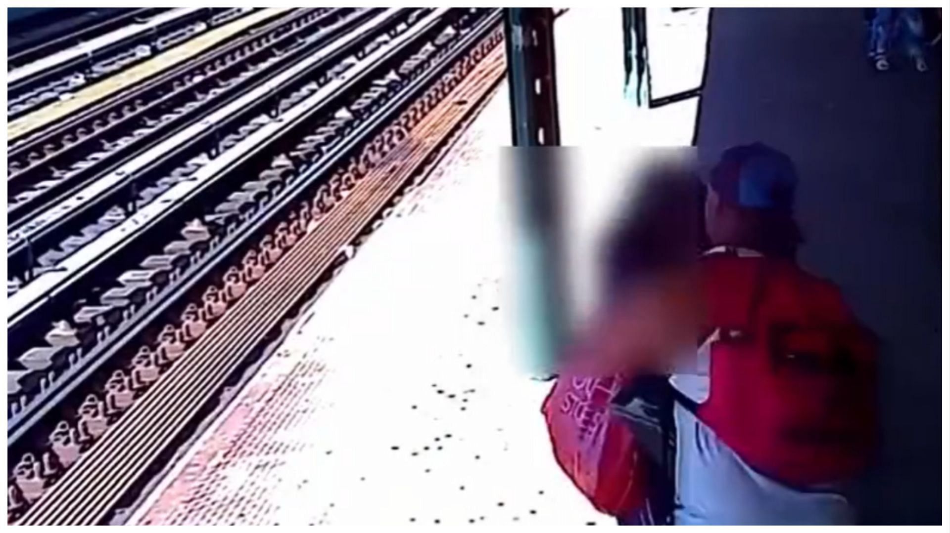 A screengrab shows the accused in white tank top allegedly grabbing the woman around her neck before throwing her onto the rails (Image via Facebook)