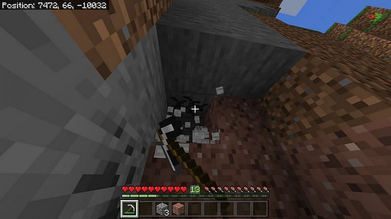 Using a pickaxe to break some nearby stone to get cobblestone in Minecraft