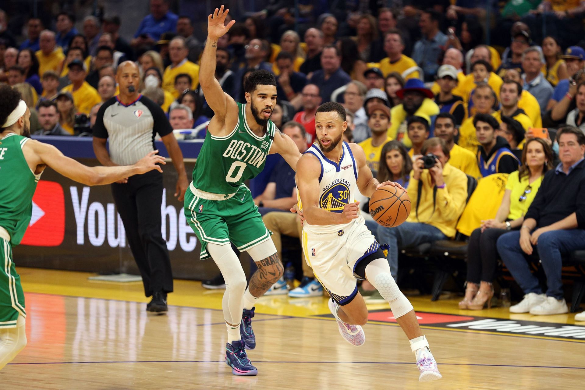 Stephen Curry of the Golden State Warriors dribbles against Jayson Tatum of the Boston Celtics.