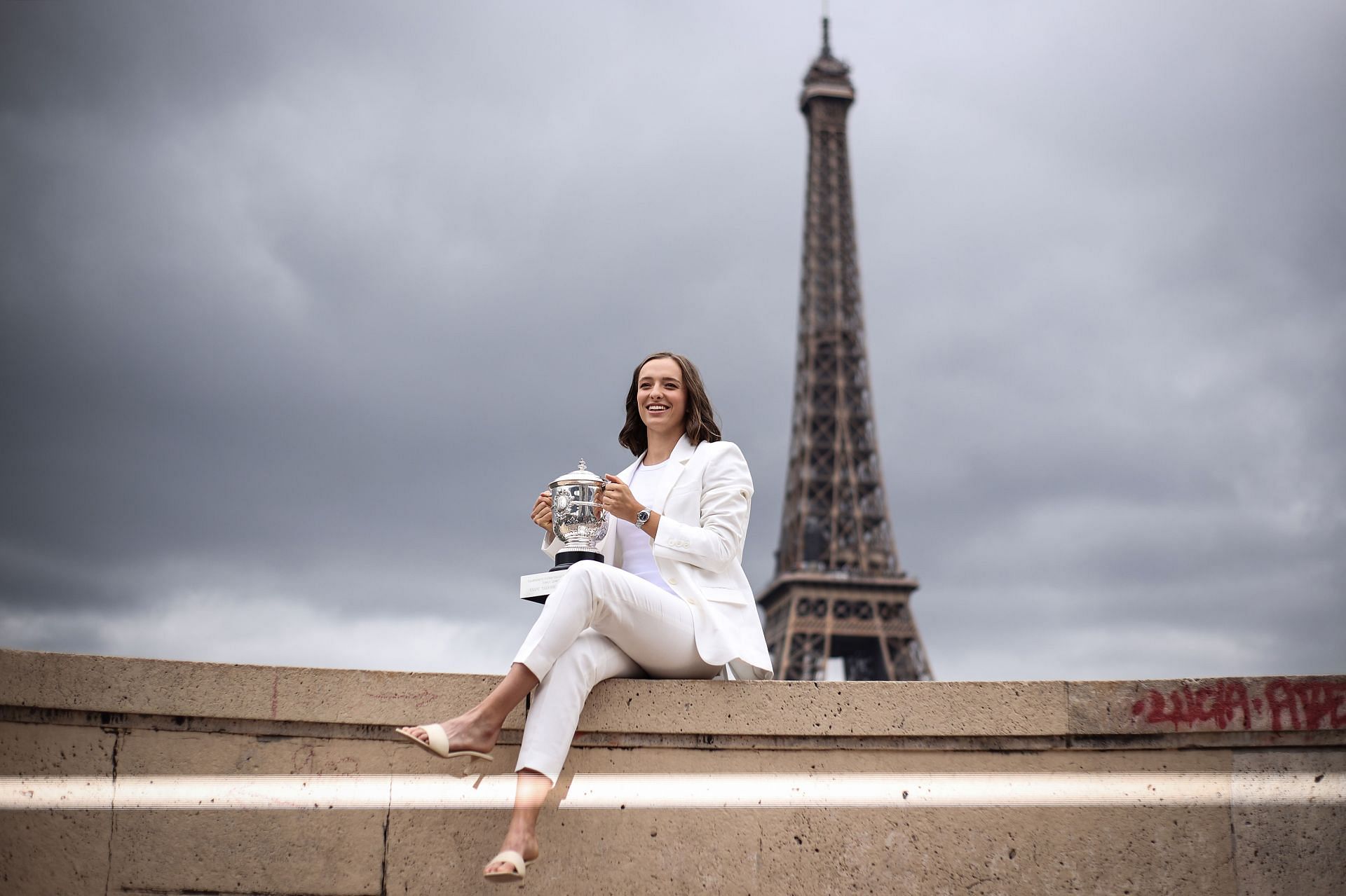 Iga Swiatek holding the Roland Garros trophy in front of the Eifel Tower