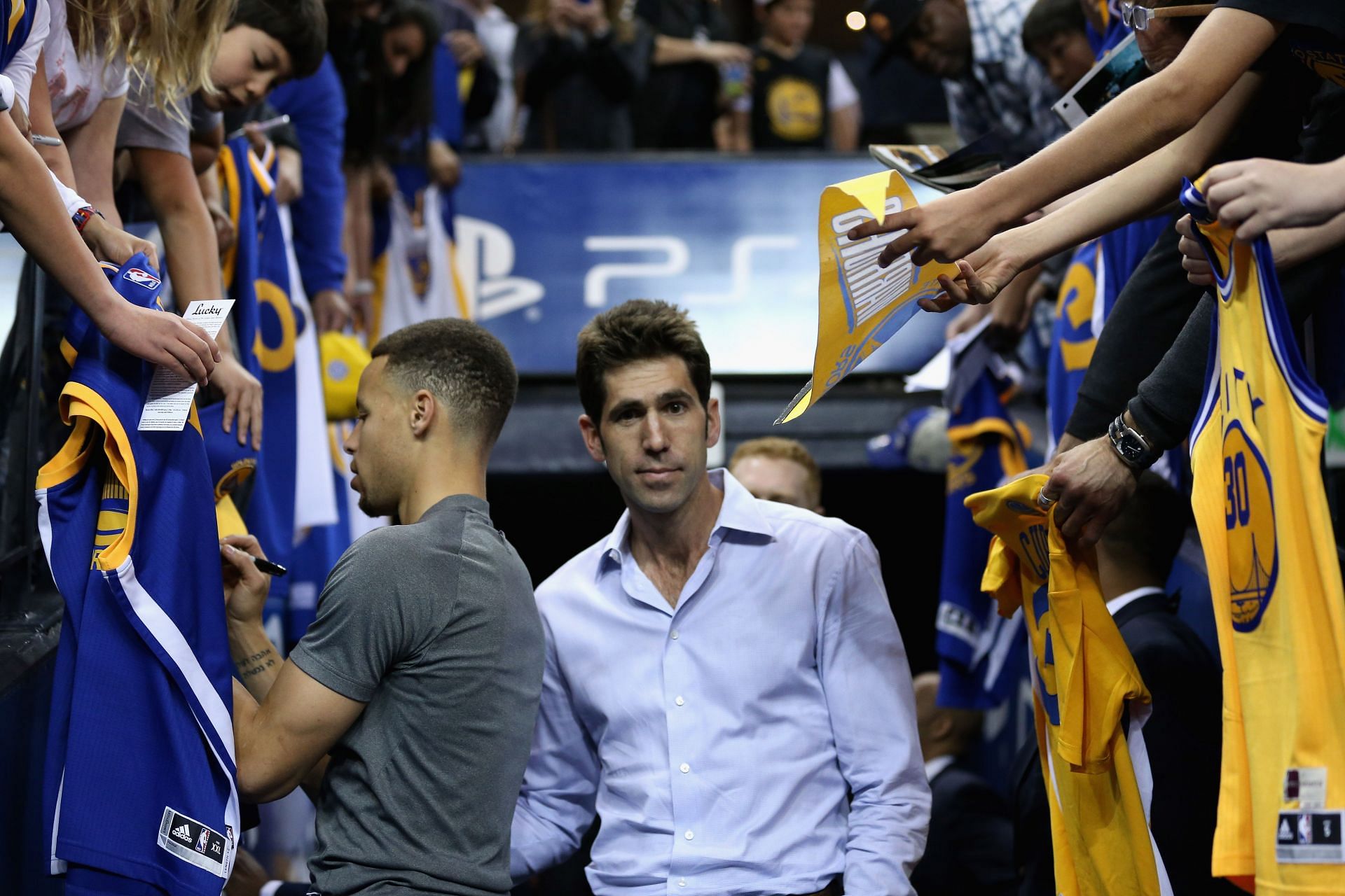 Golden State Warriors general manager Bob Myers with Steph Curry as he signs autographs