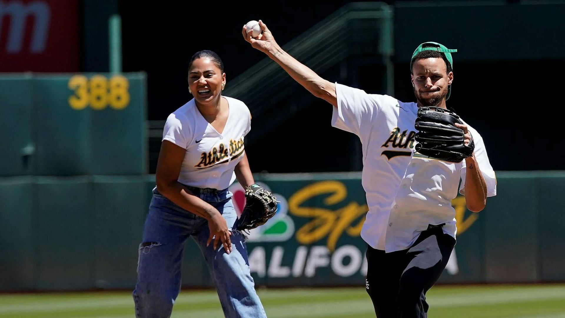 Steph Curry and his wife, Ayesha Curry, throw the first pitch at an Oakland Athletics game [Source: AP]