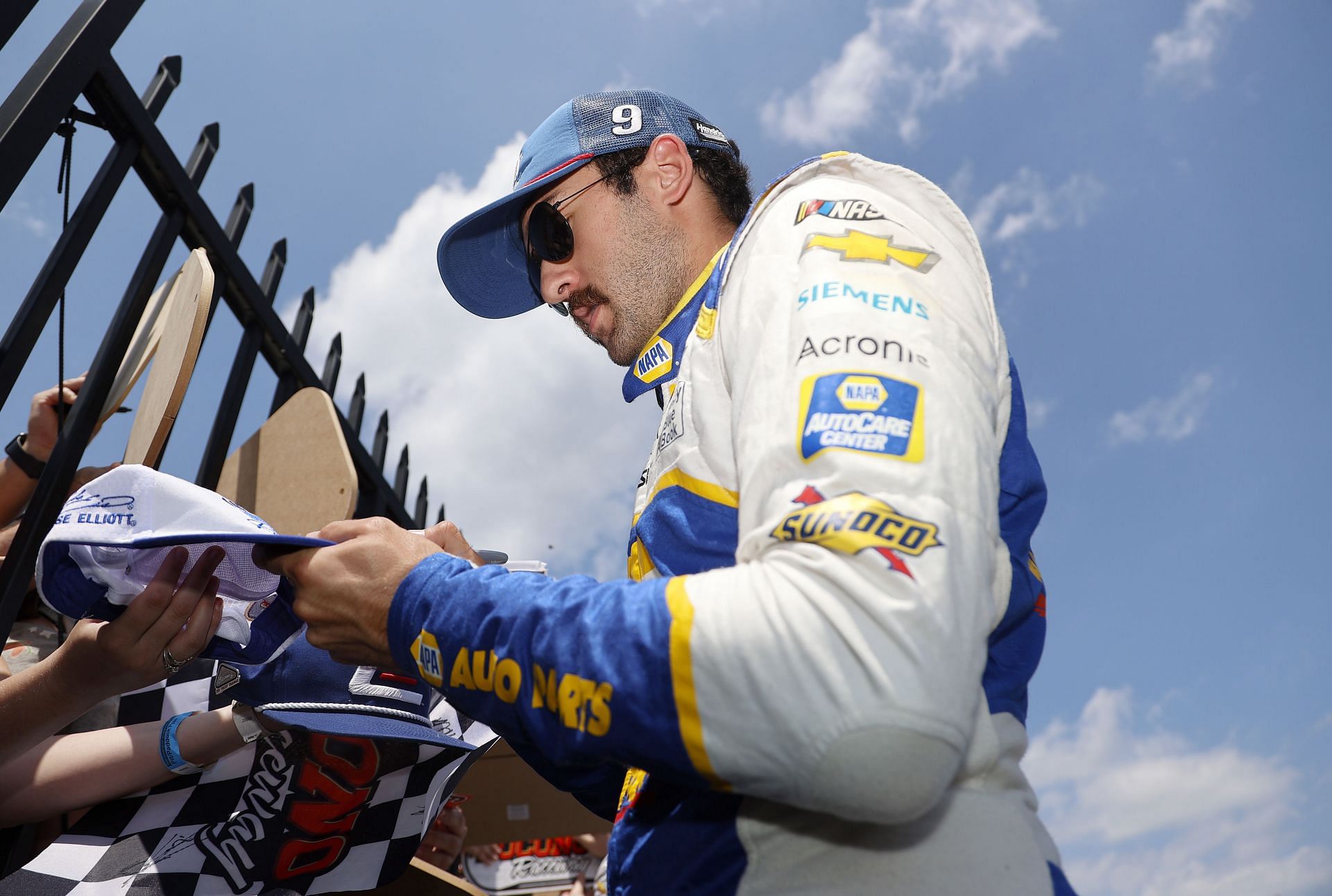 Chase Elliott signs autographs for fans in the garage area before the 2022 NASCAR Cup Series M&amp;M&#039;s Fan Appreciation 400 at Pocono Raceway in Long Pond, Pennsylvania. (Photo by Tim Nwachukwu/Getty Images)