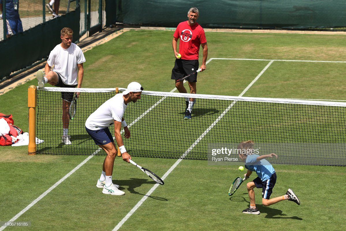 Djokovic watching his son&#039;s game play near the net