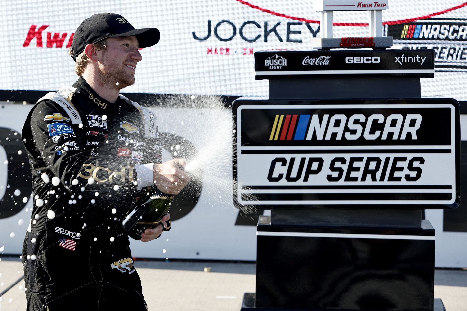 Tyler Reddick celebrate by spraying champagne in victory lane after winning the NASCAR Cup Series Kwik Trip 250 at Road America (Photo by Sean Gardner/Getty Images)