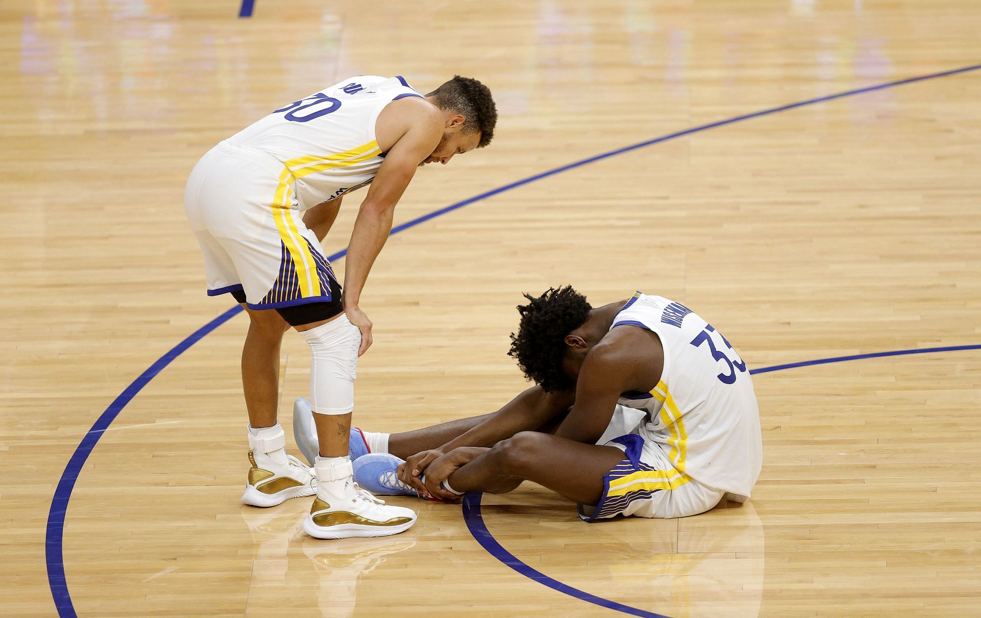 Steph Curry of the Golden State Warriors checks on teammate James Wiseman