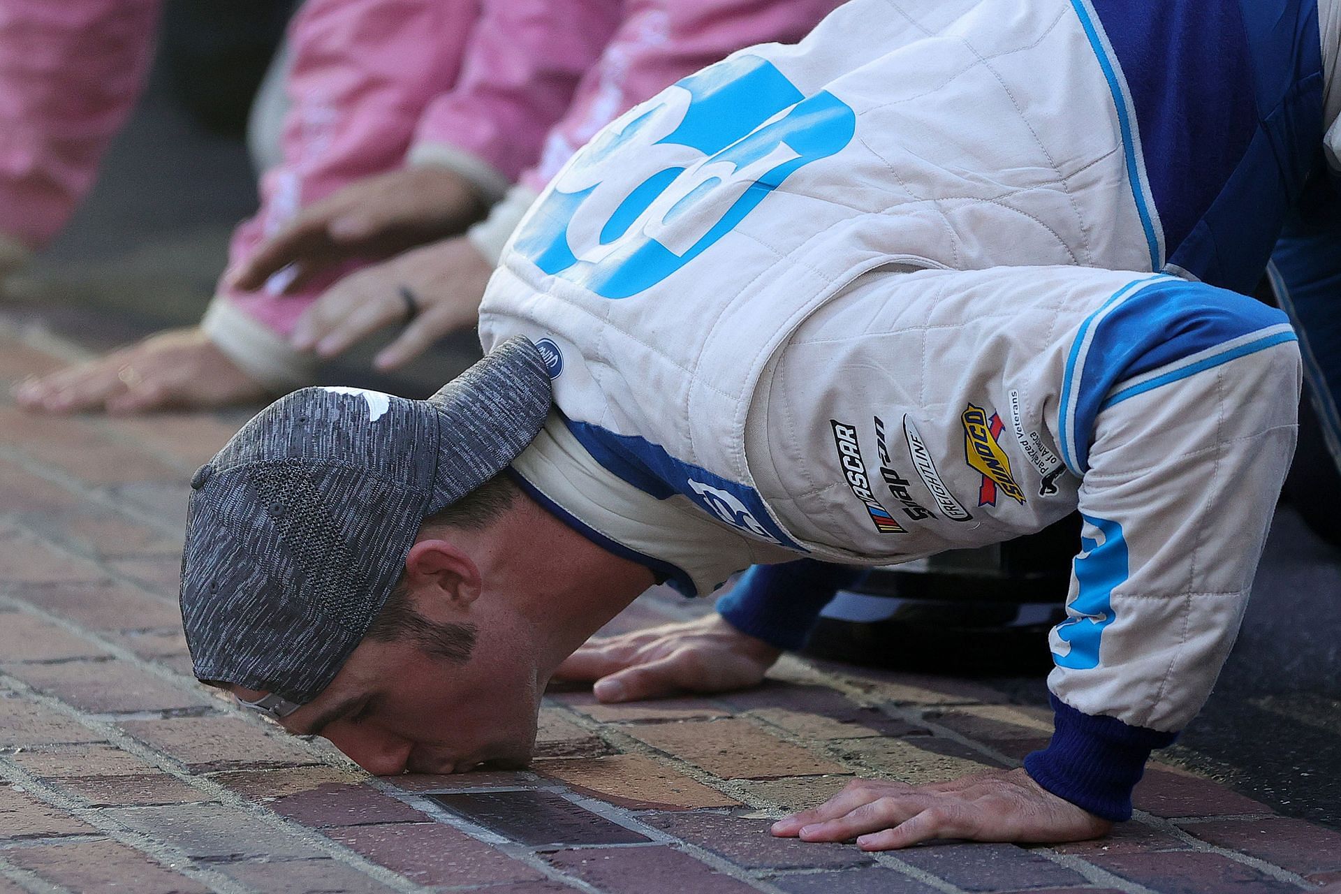 Austin Cindric kisses the yard of bricks after winning the 2021 NASCAR Xfinity Series Pennzoil 150 at the Brickyard at Indianapolis Motor Speedway in Indianapolis, Indiana (Photo by Stacy Revere/Getty Images)