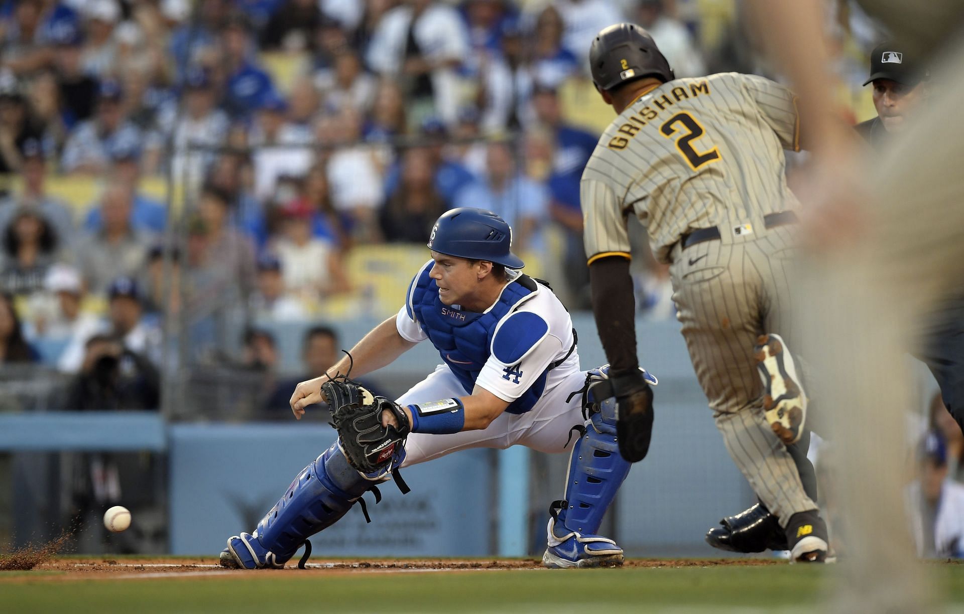 Los Angeles Dodgers Catcher Will Smith takes a throw from right fielder Chris Taylor to tag out Trent Grisham of the San Diego Padres.