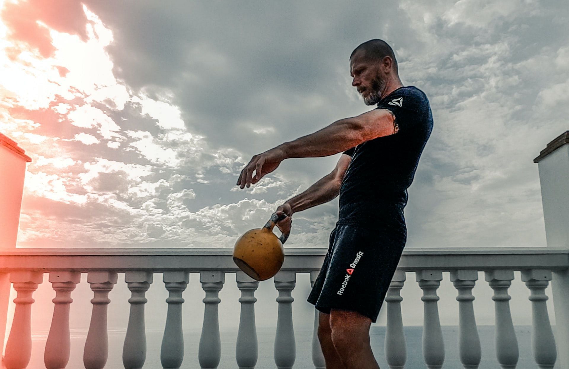A kettlebell halo develops shoulder strength and mobility. (Photo by Taco Fleur via pexels)