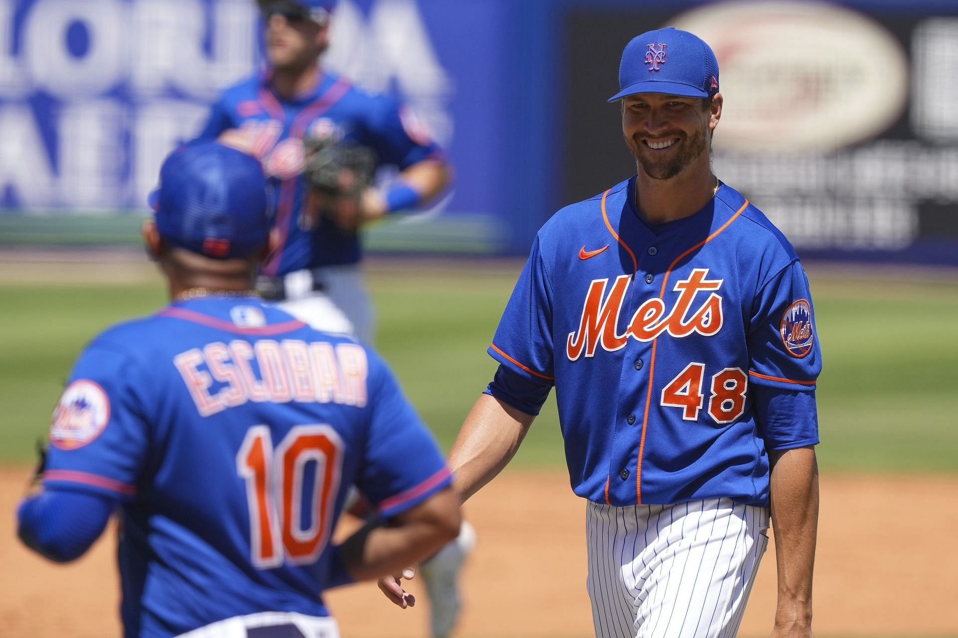 Jacob deGrom smiles as he exits the field after the third inning of the Spring Training game