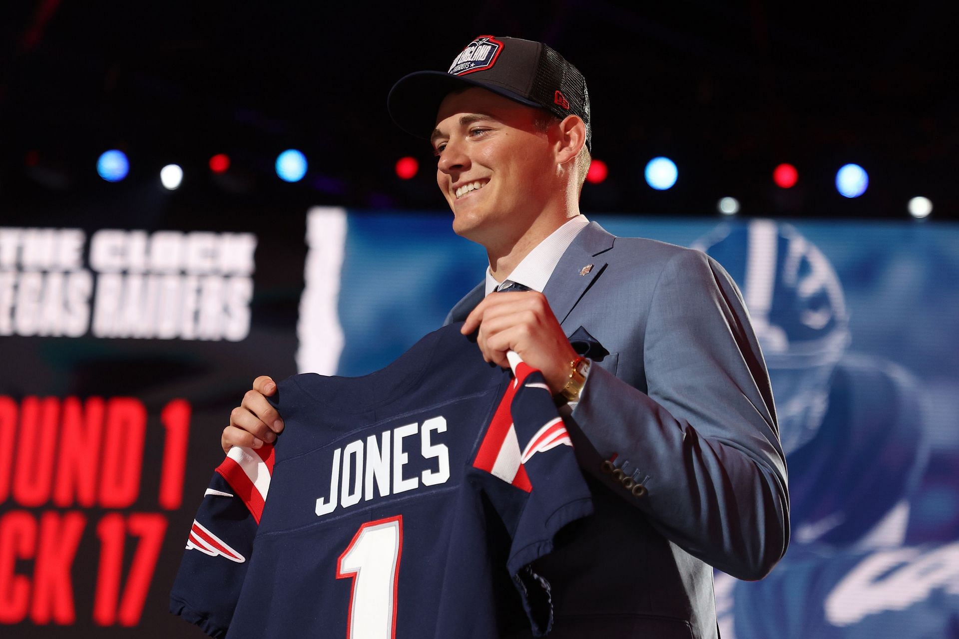 New Patriots quarterback holds his jersey at the 2021 NFL Draft