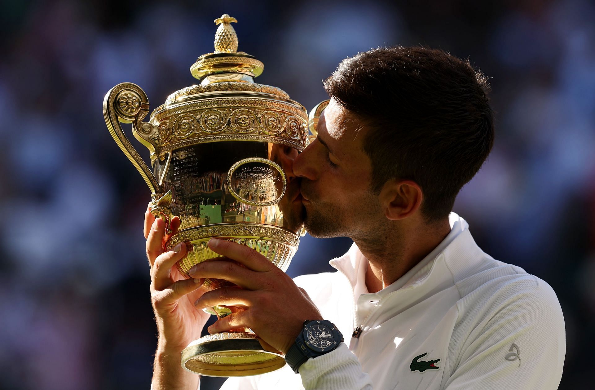 Novak Djokovic hoists his Wimbledon trophy