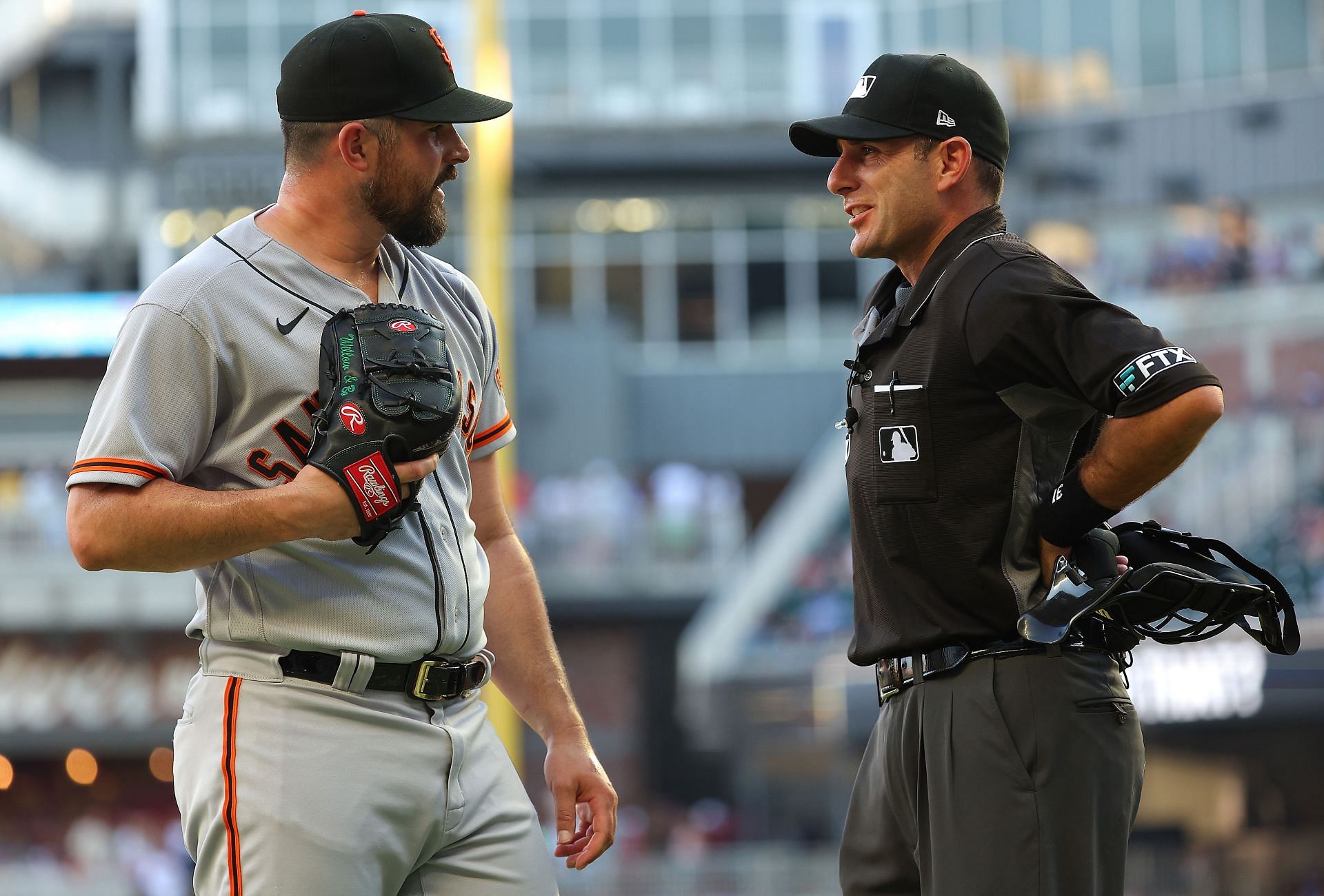 Carlos Rodon of the San Francisco Giants converses with homeplate umpire Pat Hoberg