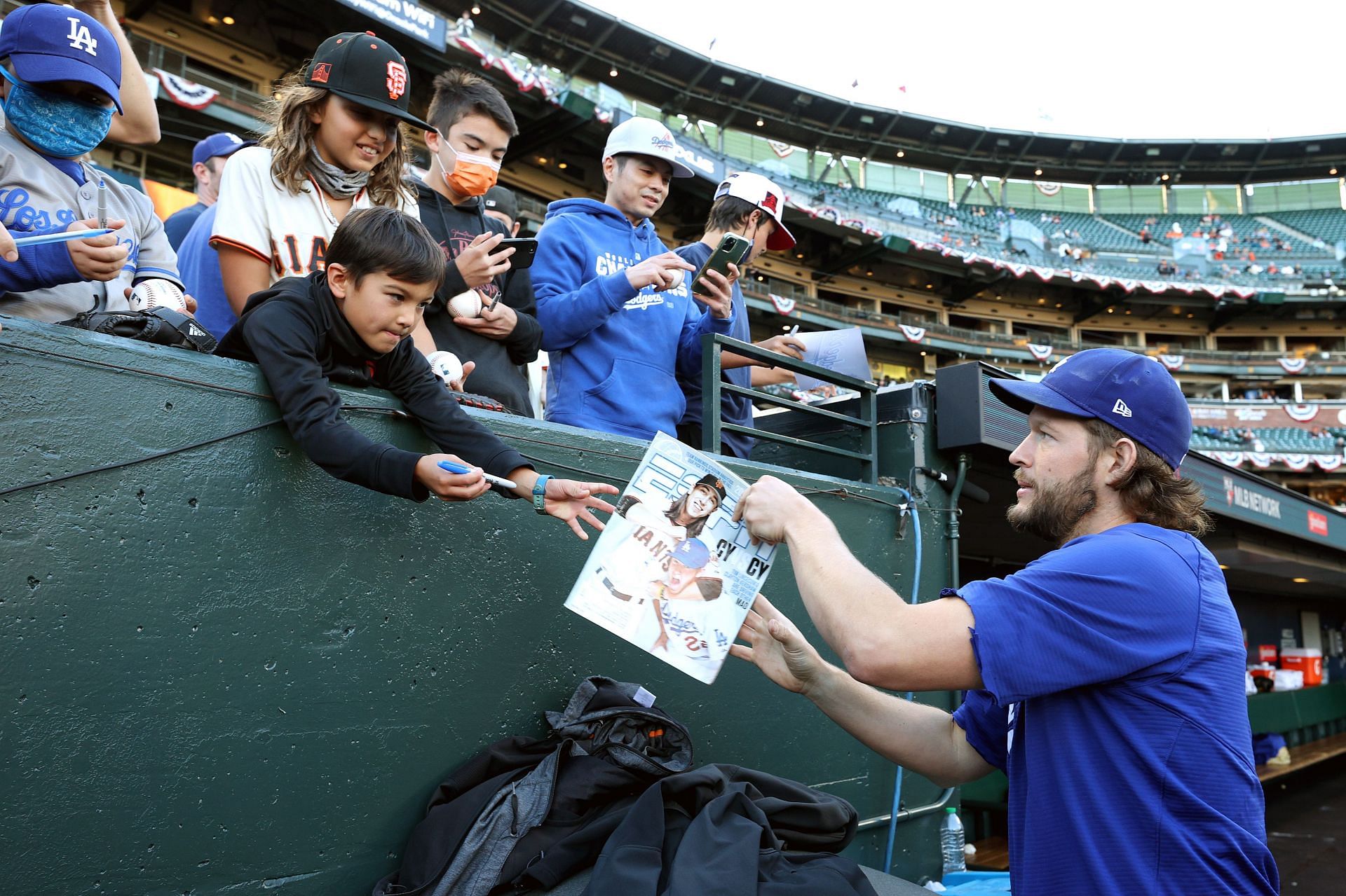 Clayton Kershaw of the Los Angeles Dodgers signs autographs before a game