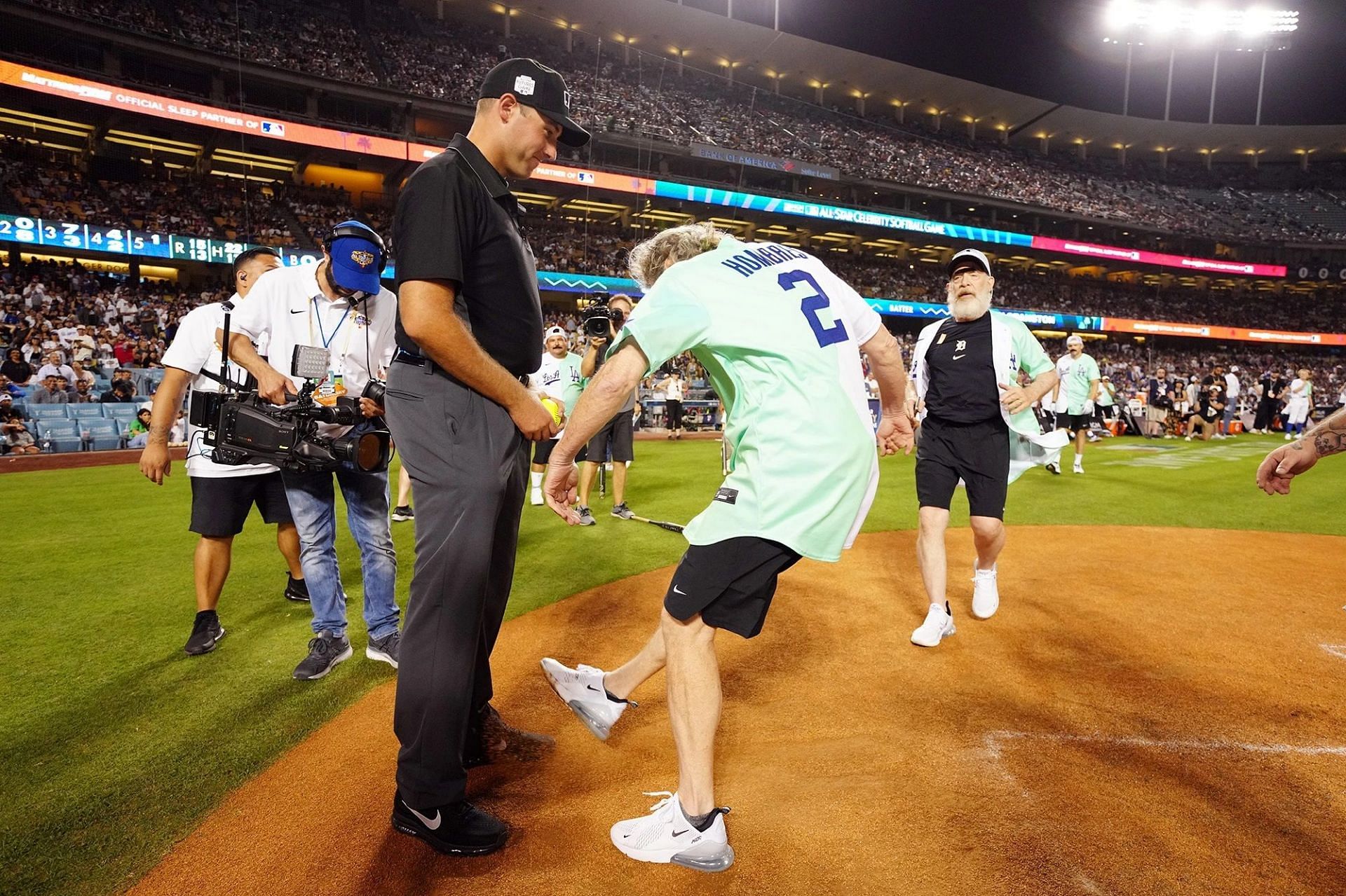 Bryan Cranston kicks dirt on the umpire during the All-Star Celebrity Softball game.