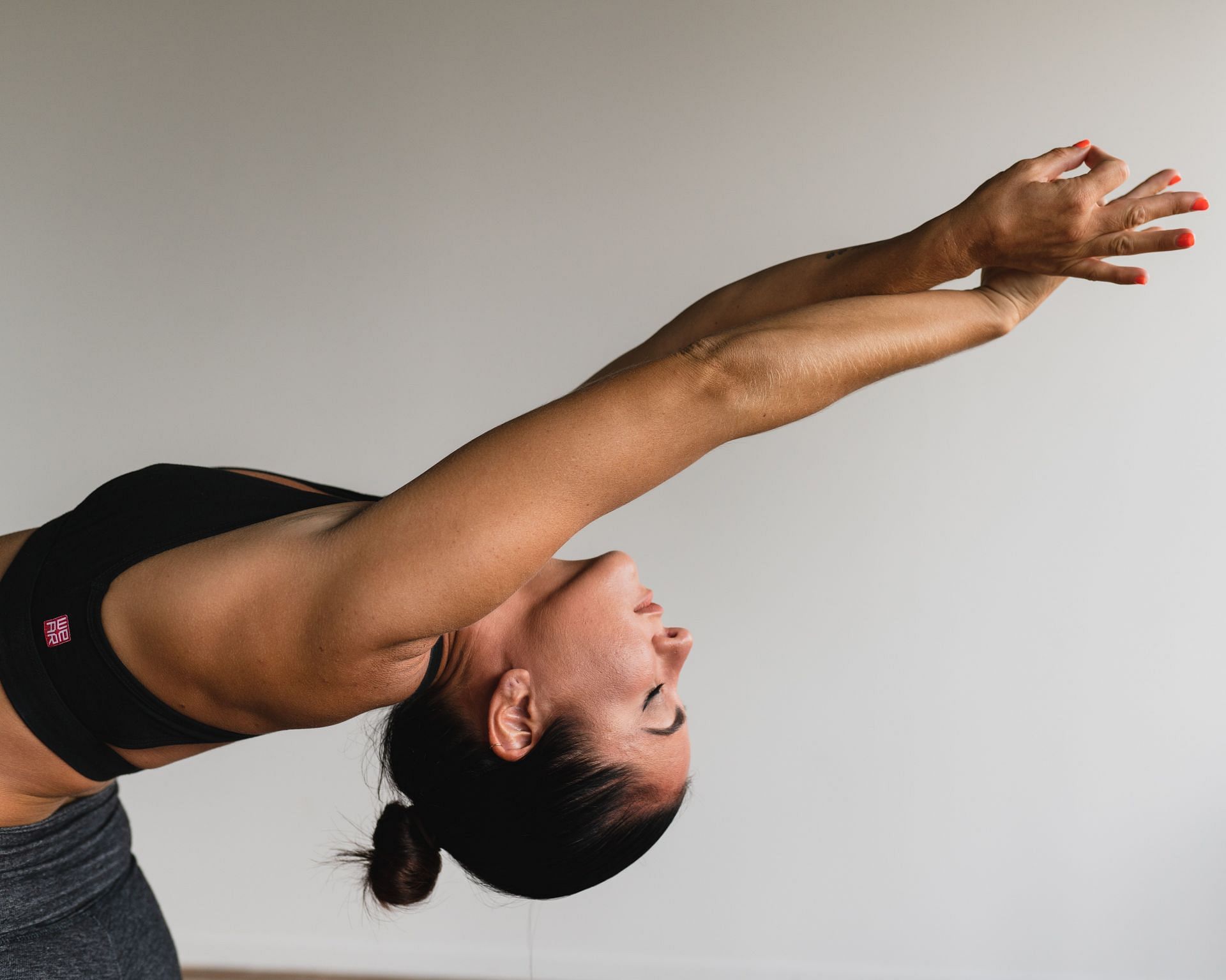 Beautiful athletic girl in black suit doing yoga. gomukhasana asana - pose  cows head. Isolated on white background. Stock Photo by ©kobrin-photo  116369566