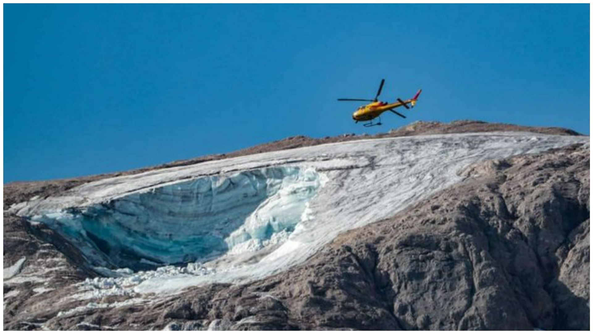 Rescue helicopters circling the Marmolada for missing hikers (Image via Anne Tootill/Twitter)