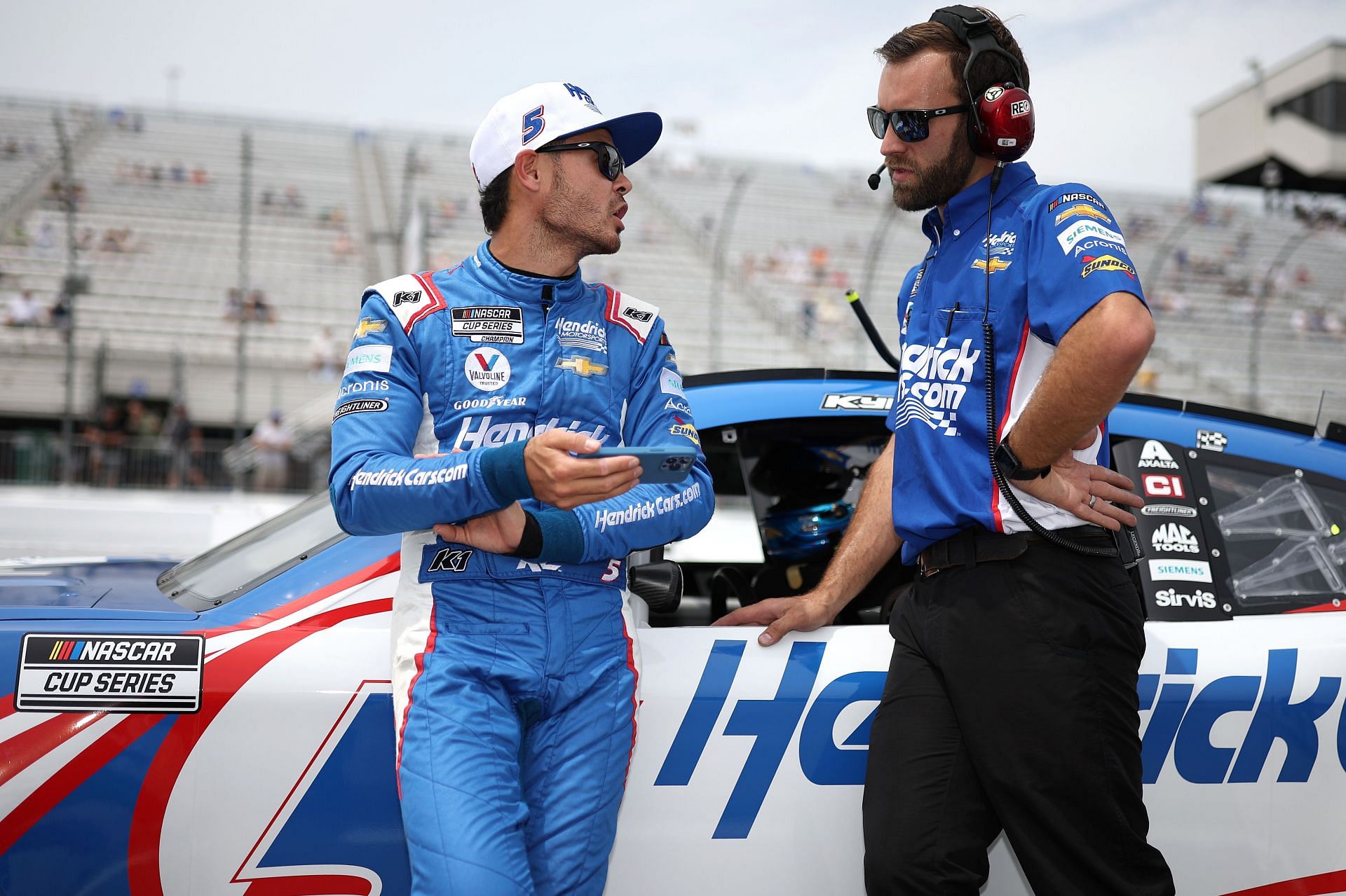 Kyle Larson and a crew member talk on the grid during qualifying for the NASCAR Cup Series Ambetter 301 at New Hampshire Motor Speedway