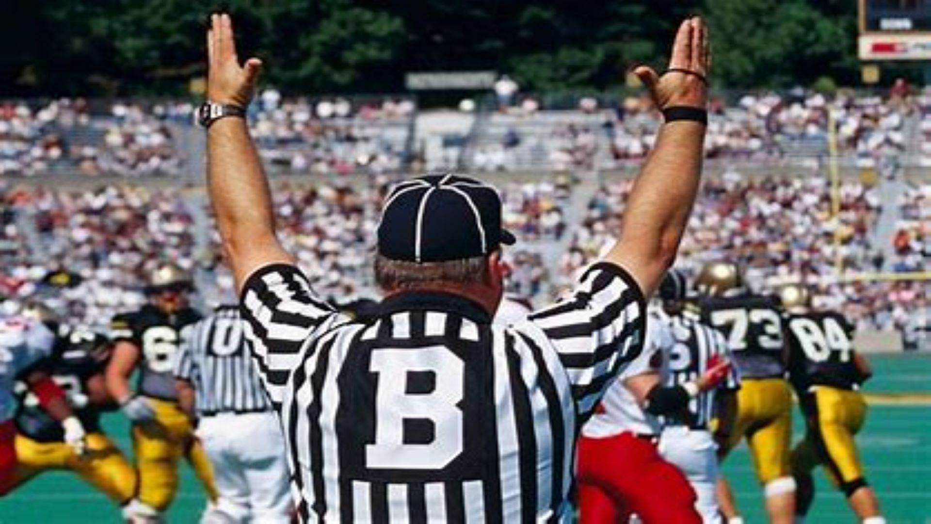 Football back judge signals for a touchdown