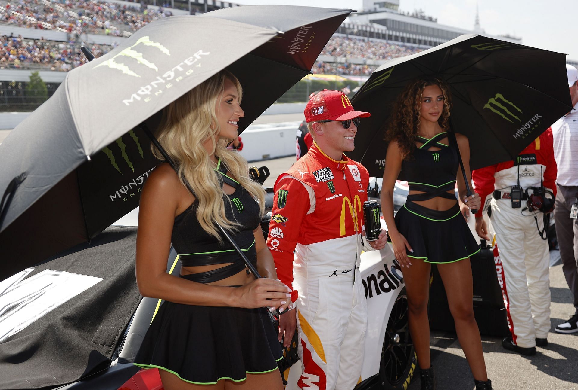 Ty Gibbs, driver of the #45 McDonald&#039;s Toyota, poses with Monster Energy models on the grid before the NASCAR Cup Series M&amp;M&#039;s Fan Appreciation 400 at Pocono Raceway on July 24, 2022, in Long Pond, Pennsylvania (Photo by Tim Nwachukwu/Getty Images)