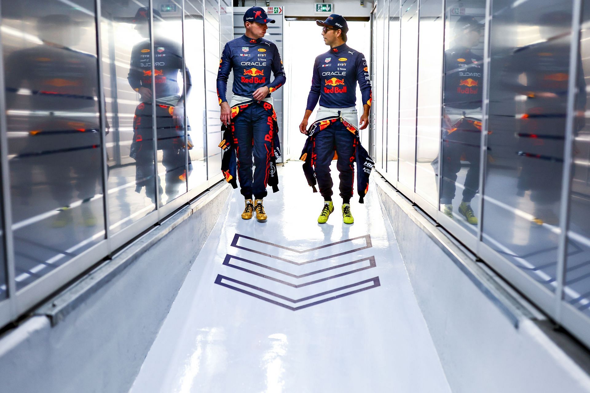 Red Bull drivers Max Verstappen (left) and Sergio Perez (right) walk in the team garage during the 2022 F1 French GP weekend. (Photo by Mark Thompson/Getty Images)