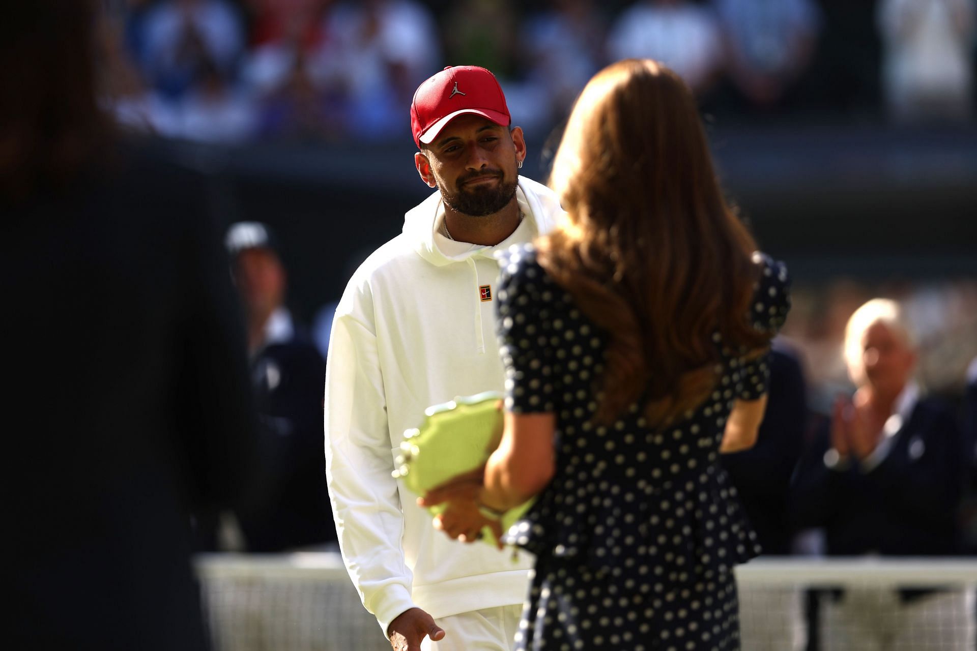Nick Kyrgios being handed the runner-up trophy by the Duchess of Cambridge
