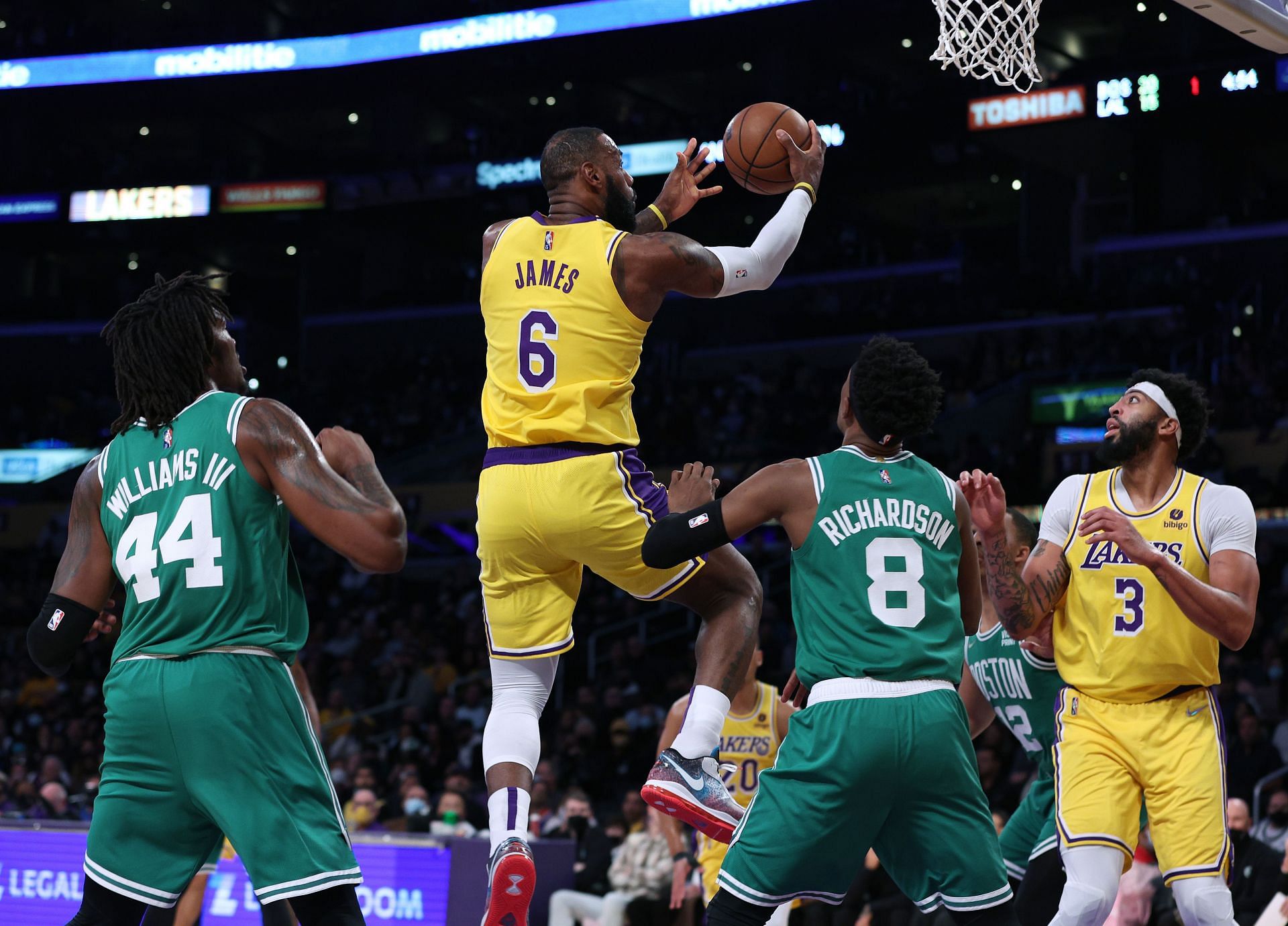 LeBron James #6 of the Los Angeles Lakers scores on a layup in front of Robert Williams III #44 and Josh Richardson #8 of the Boston Celtics